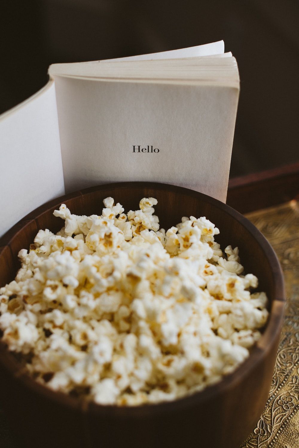A bowl of popcorn and a book on a table photo