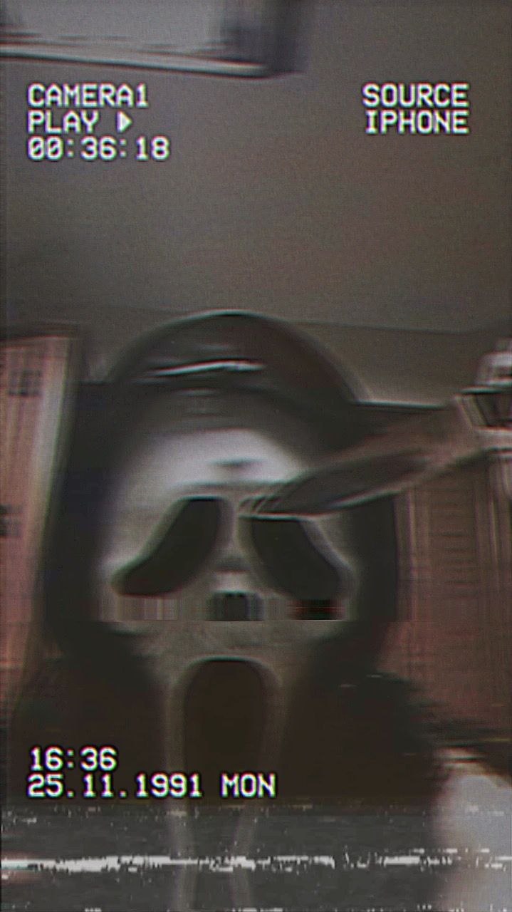 A still from a film reel showing a man wearing a mask - Ghostface, ghost