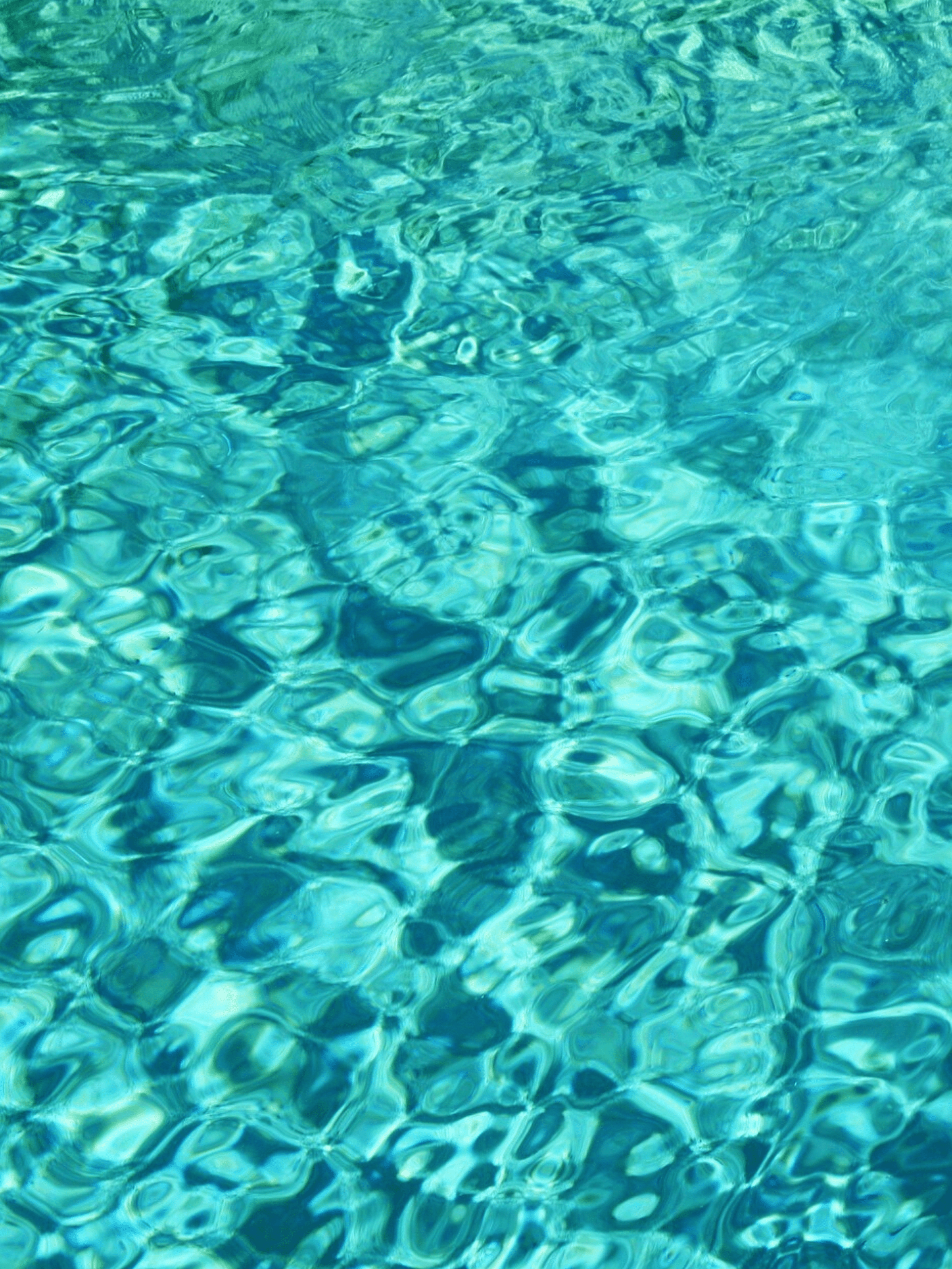 A close up of the water in a pool with light reflecting off the surface. - Aqua