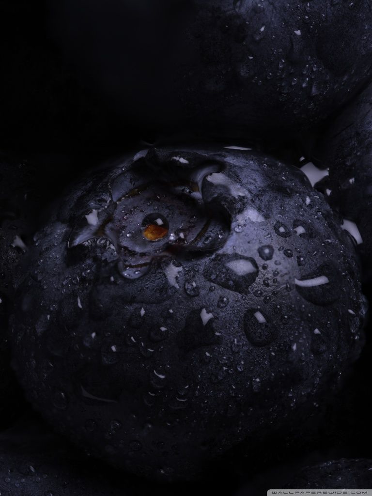 A close up of a blackberry with water droplets on it - Macro