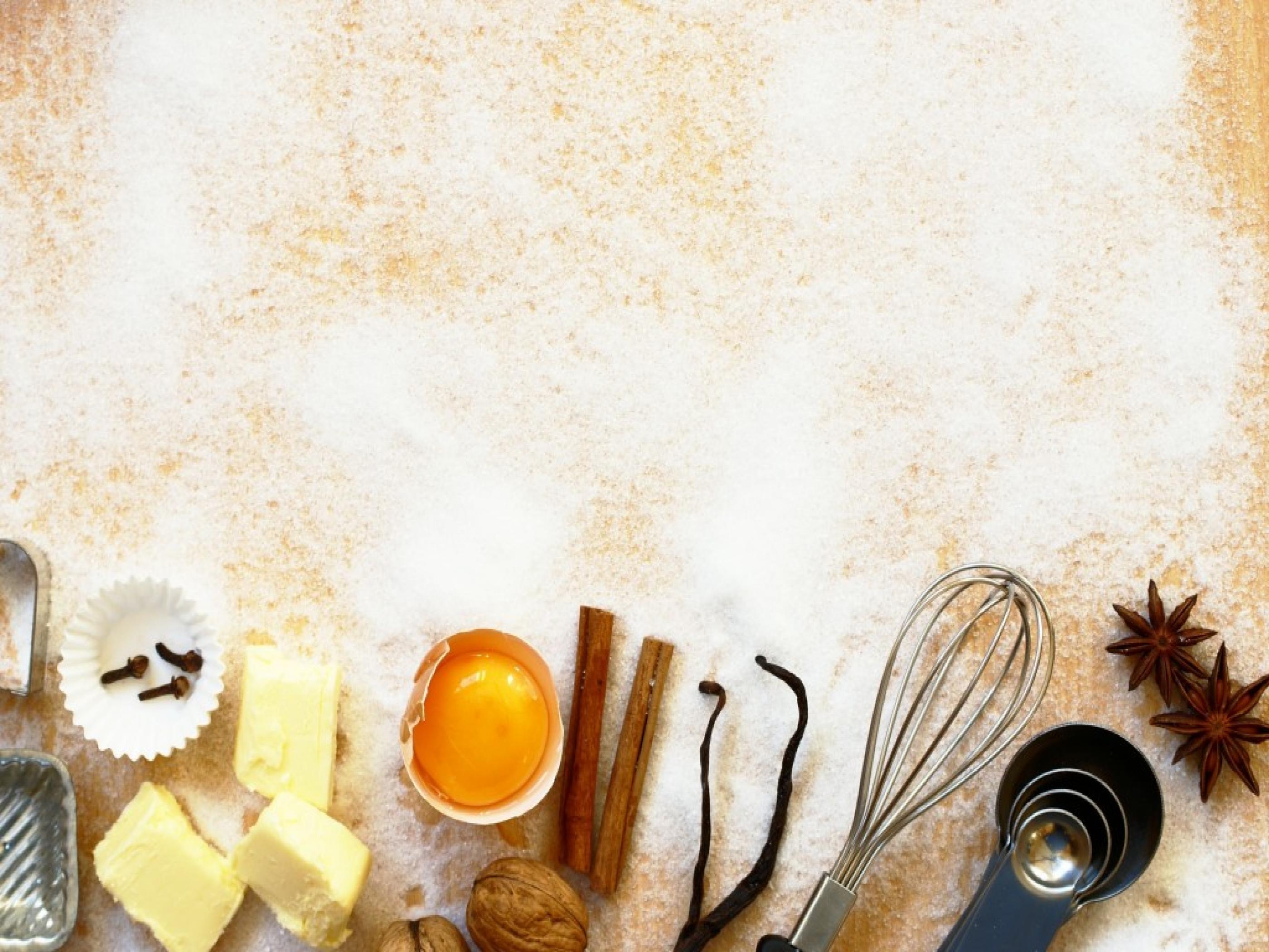 Various baking ingredients including butter, sugar, flour, eggs, and spices on a counter. - Bakery