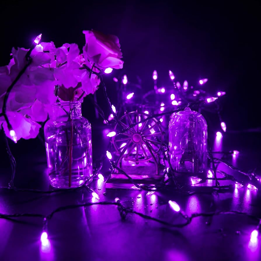 Purple fairy lights on a table with purple flowers - Fairy lights