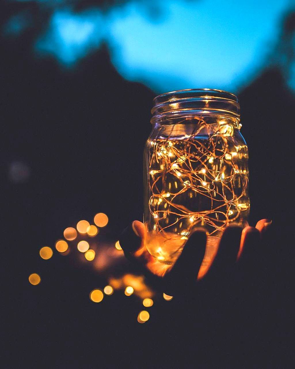 A hand holding a jar with lights inside - Fairy lights