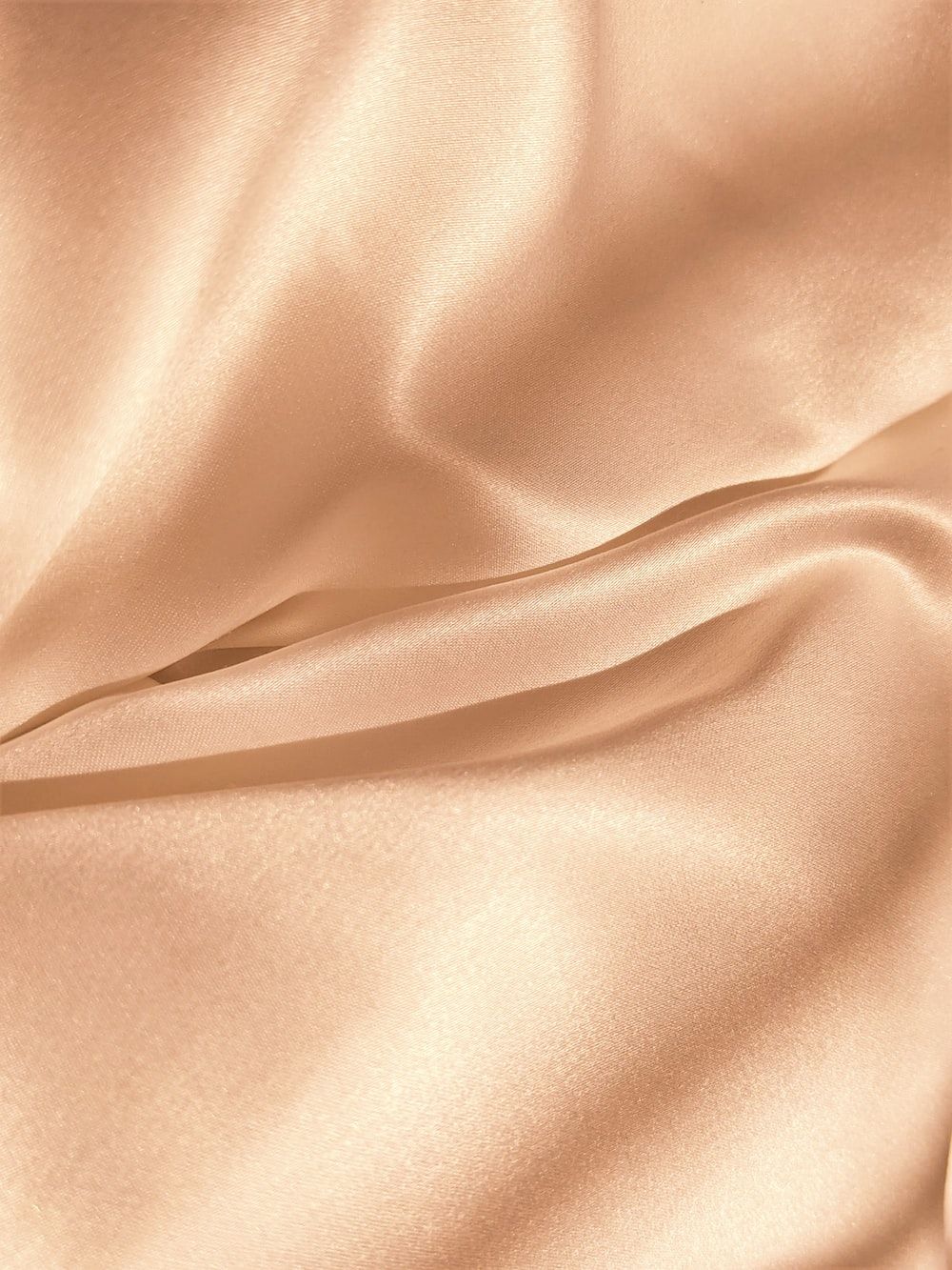 A close up of a silk sheet in a champagne color. - Silk