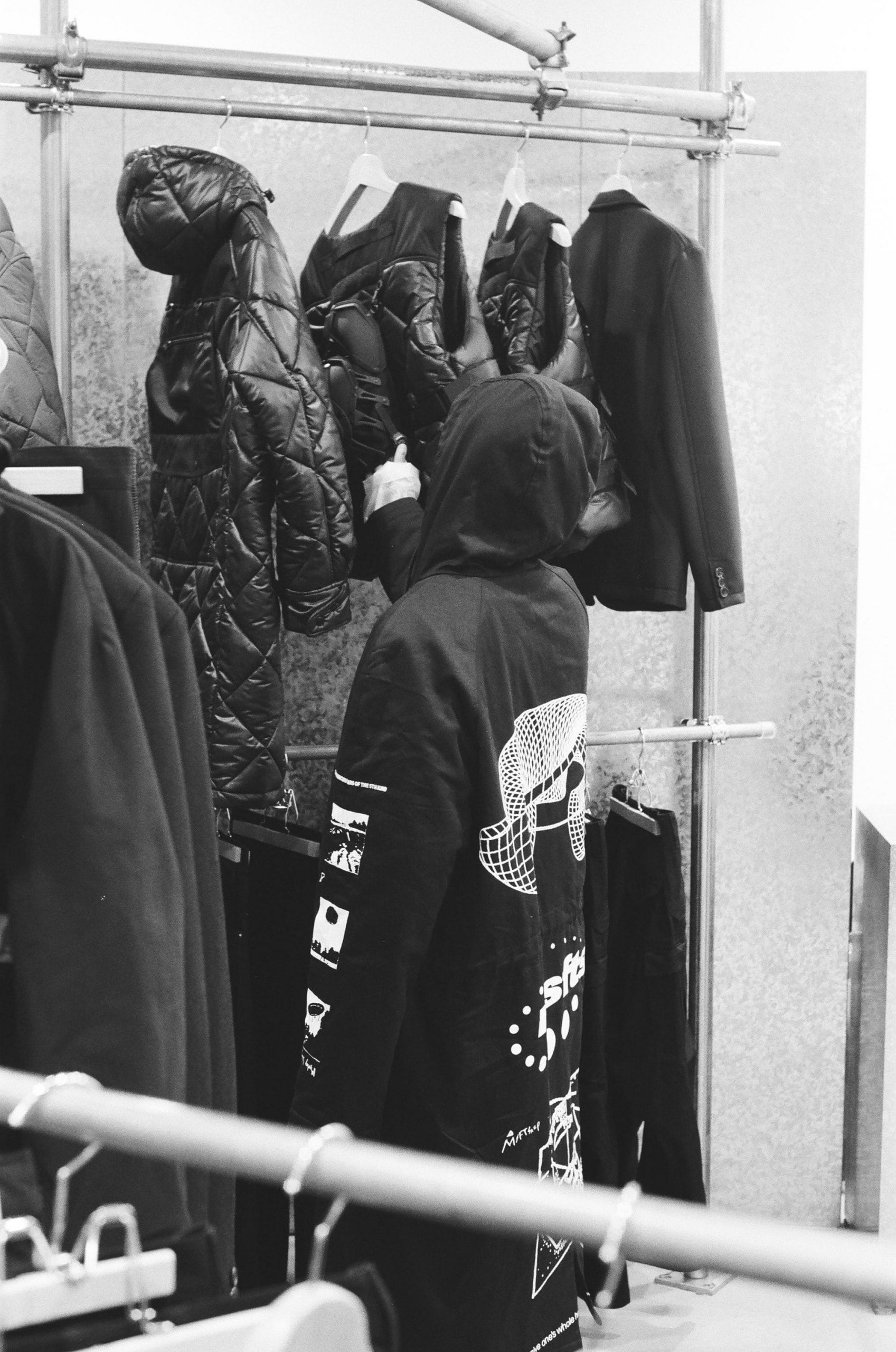A man looking at clothes on a rack - New Balance