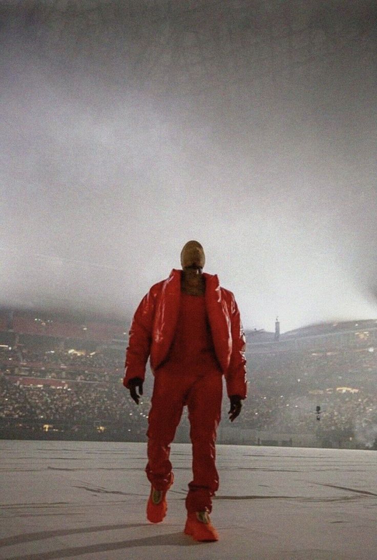 A man in red is standing on the field - Kanye West