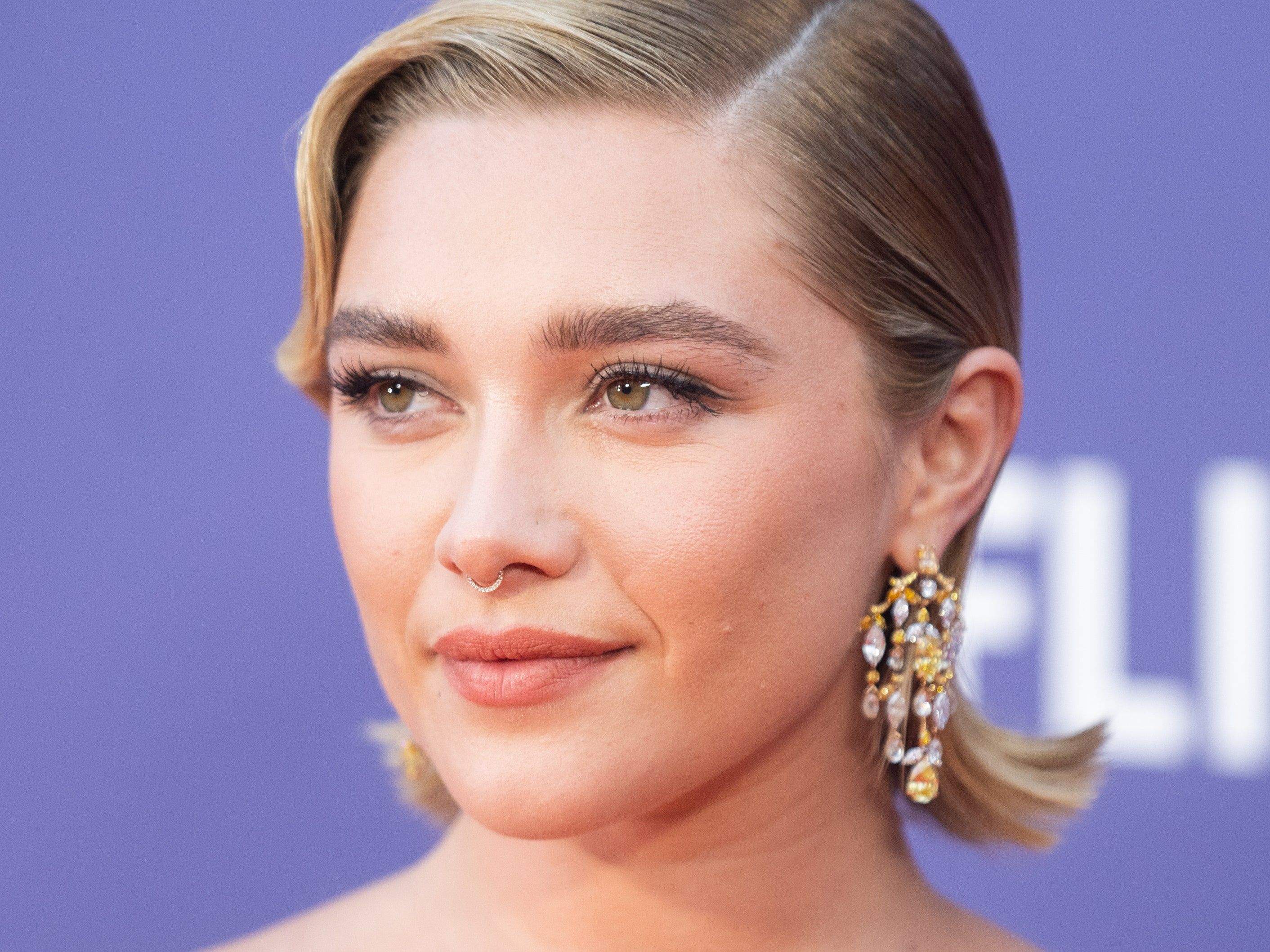 Close up of Florence Pugh with a nose ring and short blonde hair. - Florence Pugh