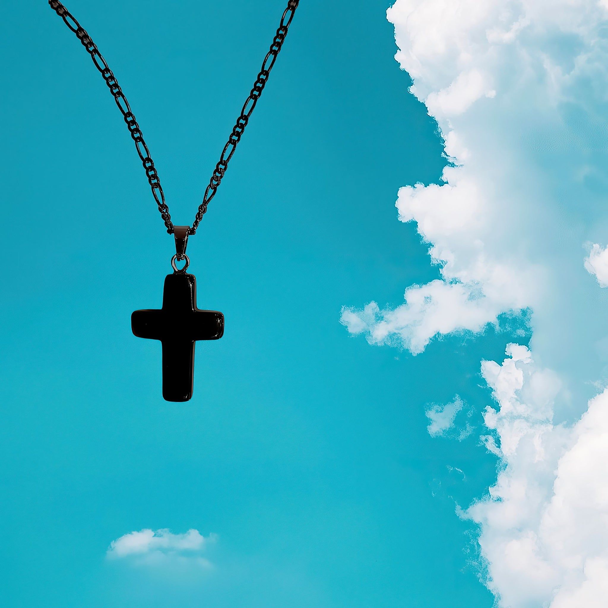 A black cross necklace against a blue sky - Cross