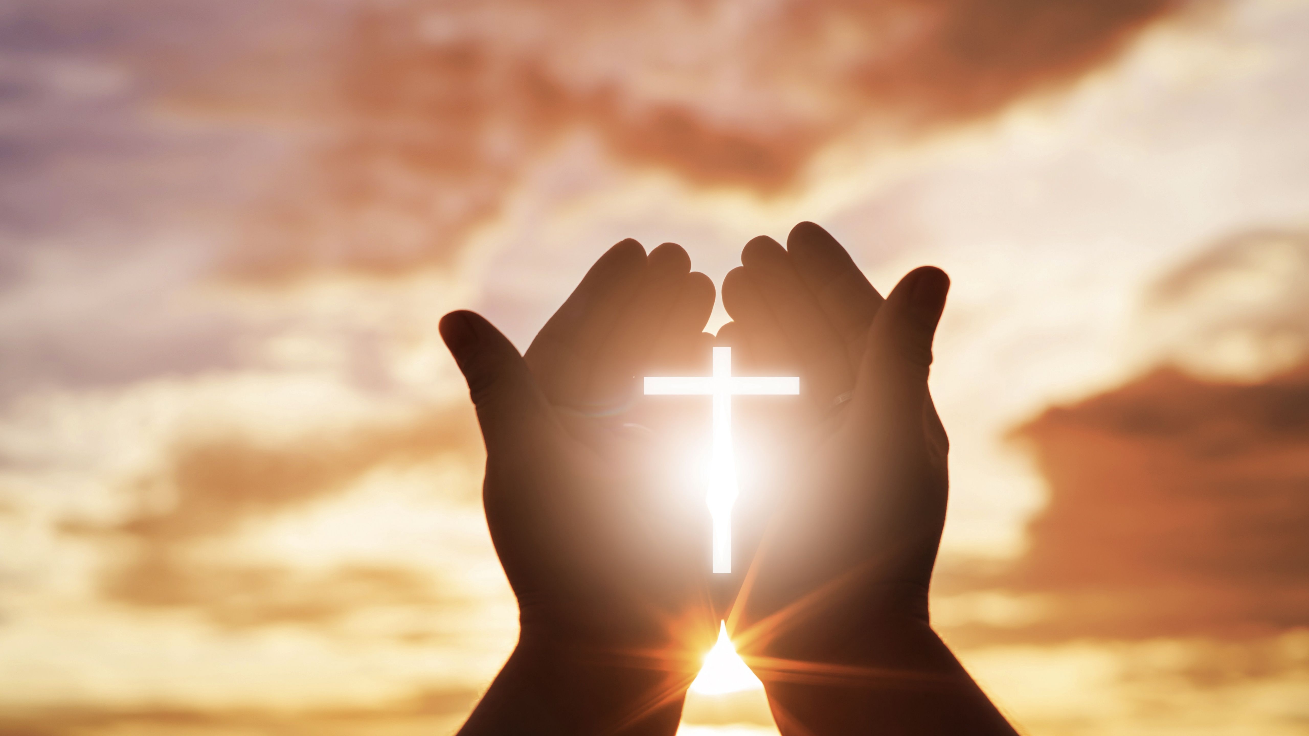 Hands holding a cross with the sun behind it - Cross