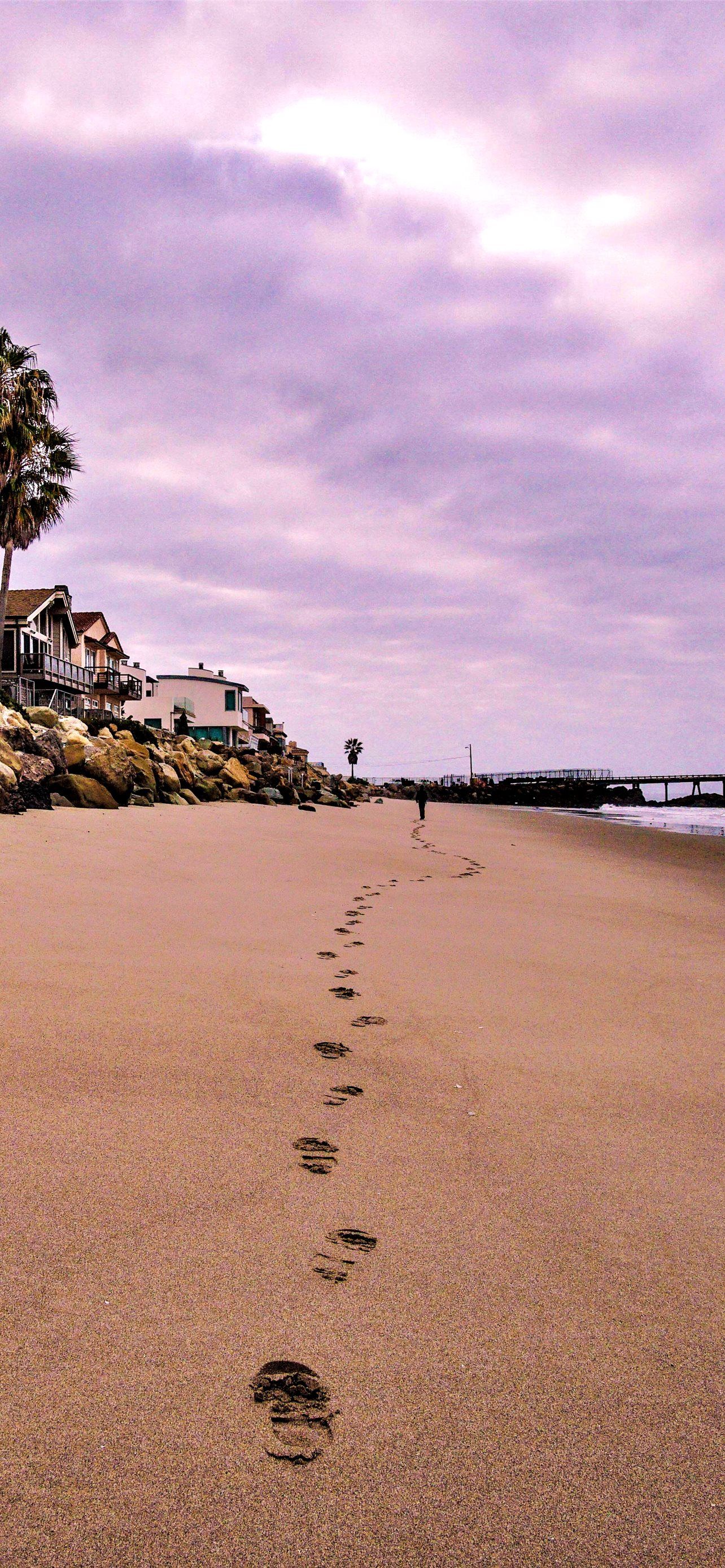 A beach with footprints in the sand - Beach
