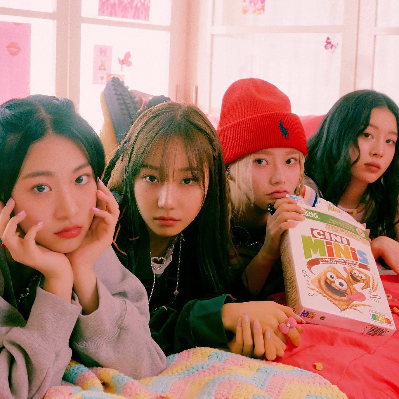 4 girls from the group GIdle sitting on a bed - FIFTY FIFTY