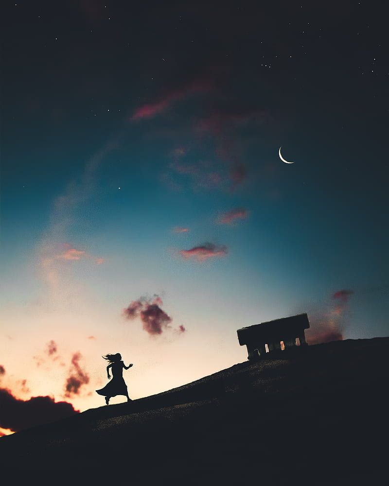 A woman runs towards a bench under a night sky - Rogue