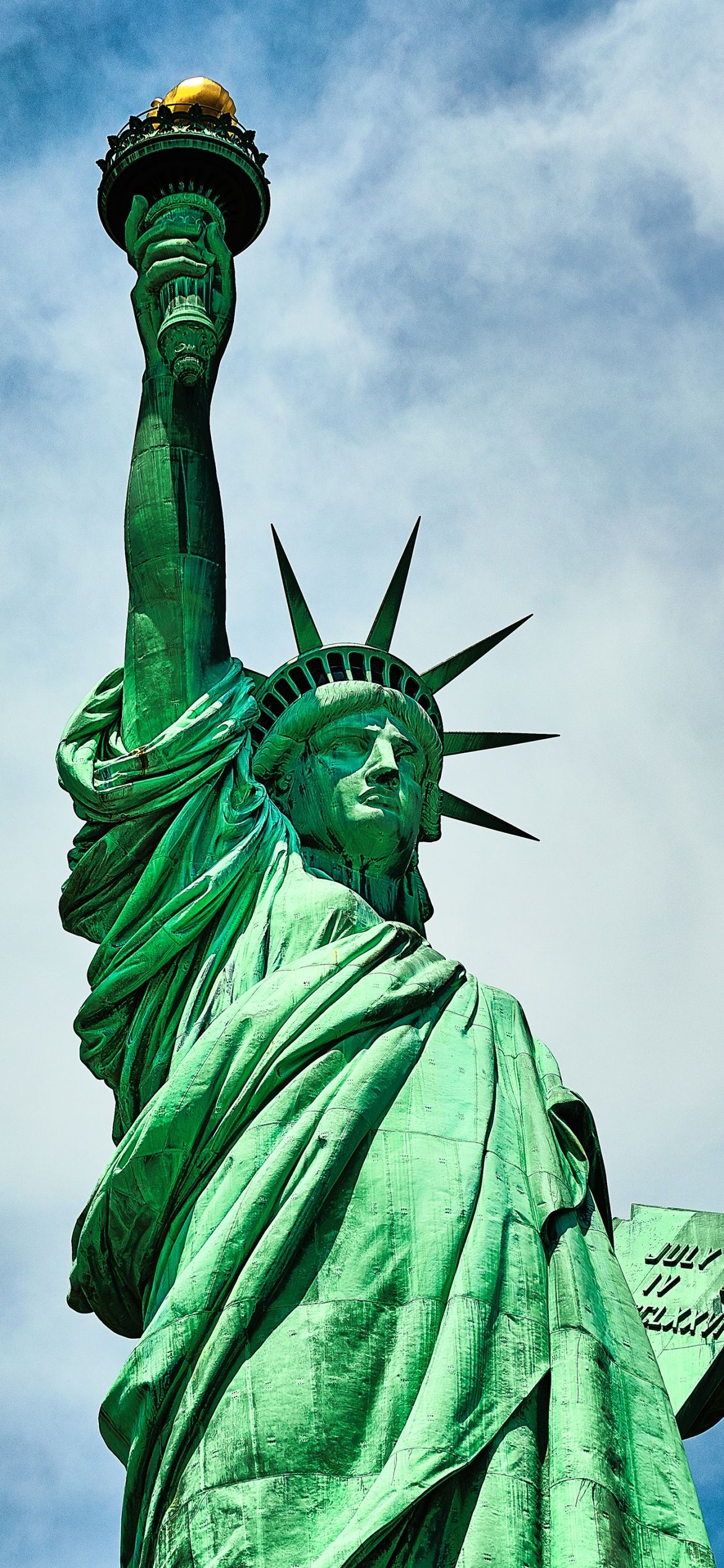 The statue of liberty with a blue sky in the background - Statue