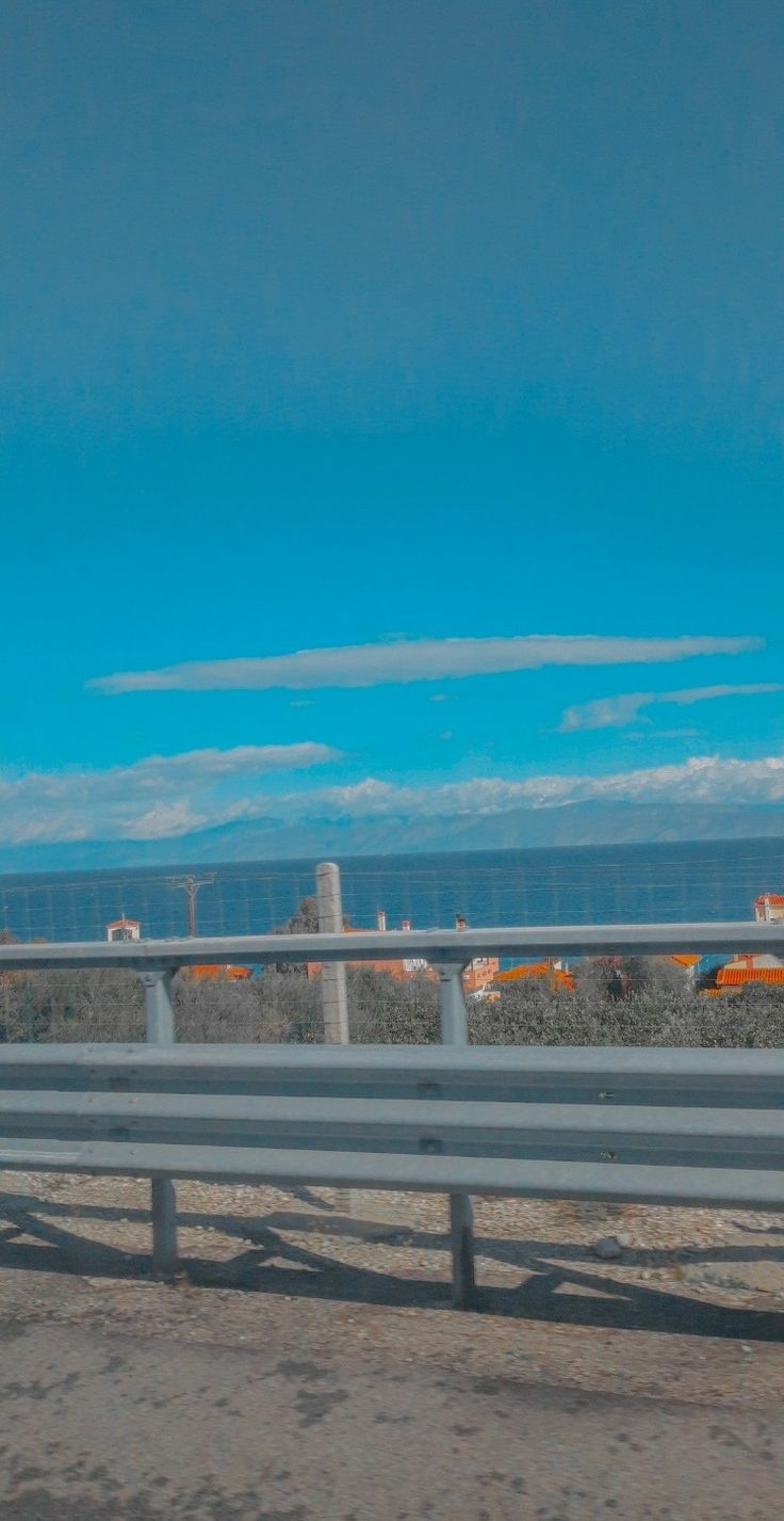 A view of the ocean and mountains from a moving car. - Outdoors