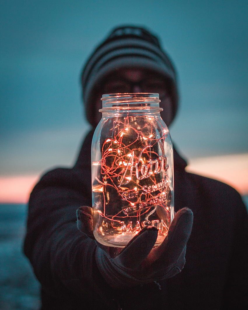 A man holding a jar with lights inside. - Fairy lights