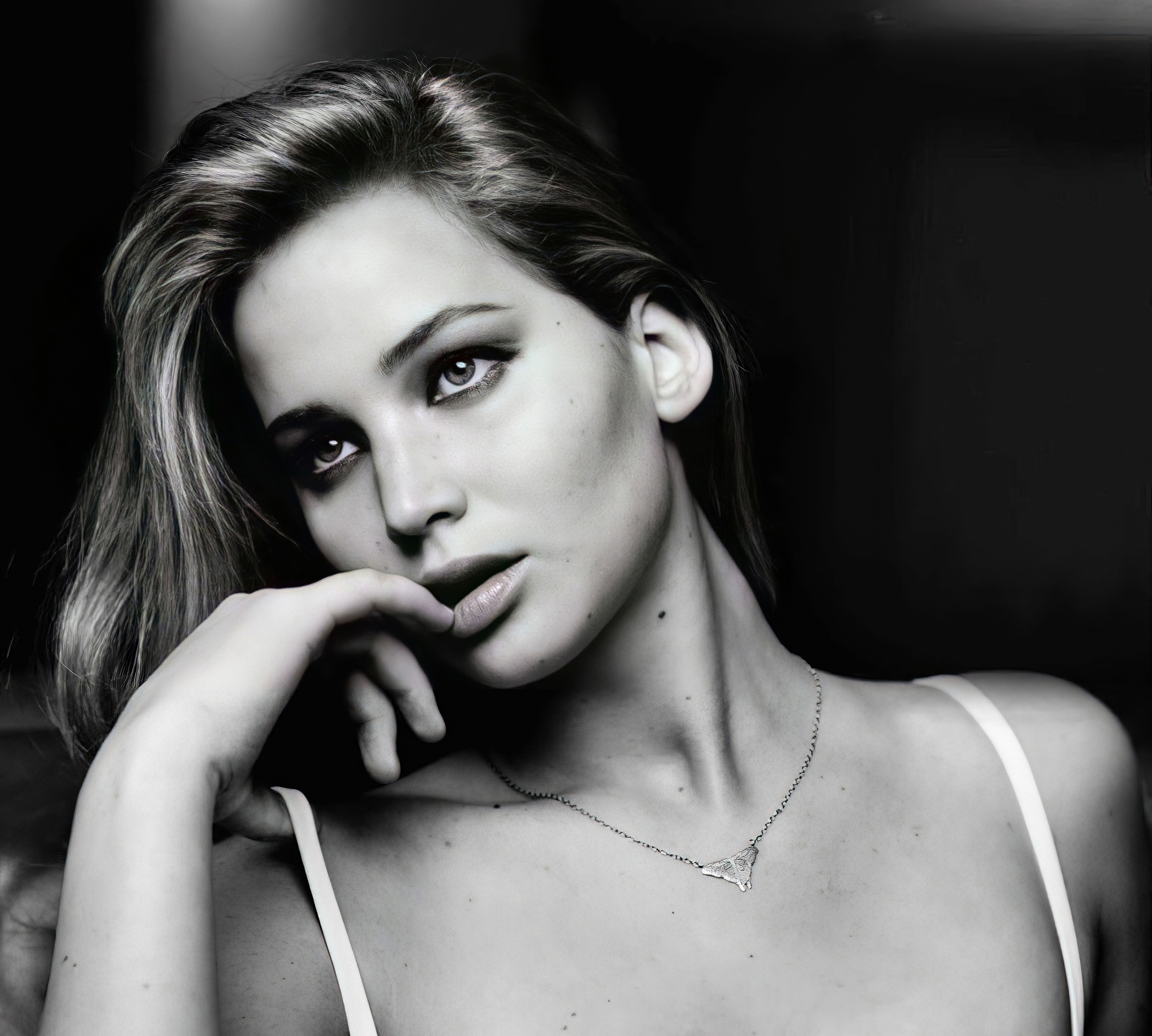 A black and white photo of a woman with a hand on her chin. - Jennifer Lawrence