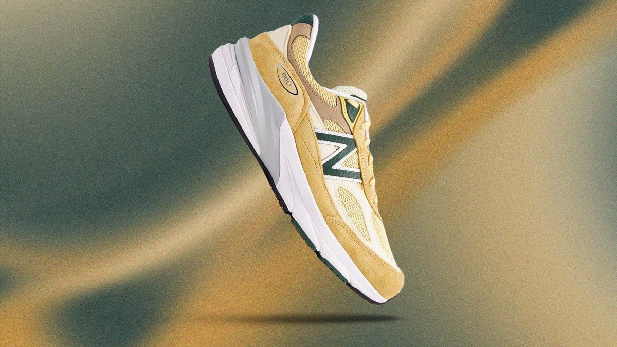 A pair of yellow New Balance sneakers on a green and brown background - New Balance