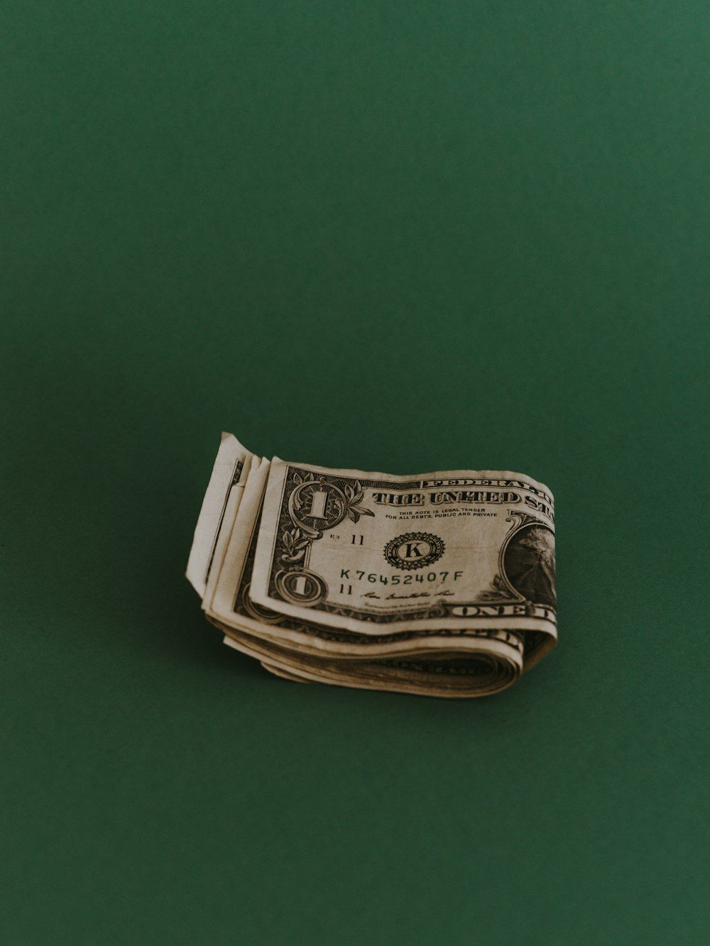 A dollar bill on a green background - Money