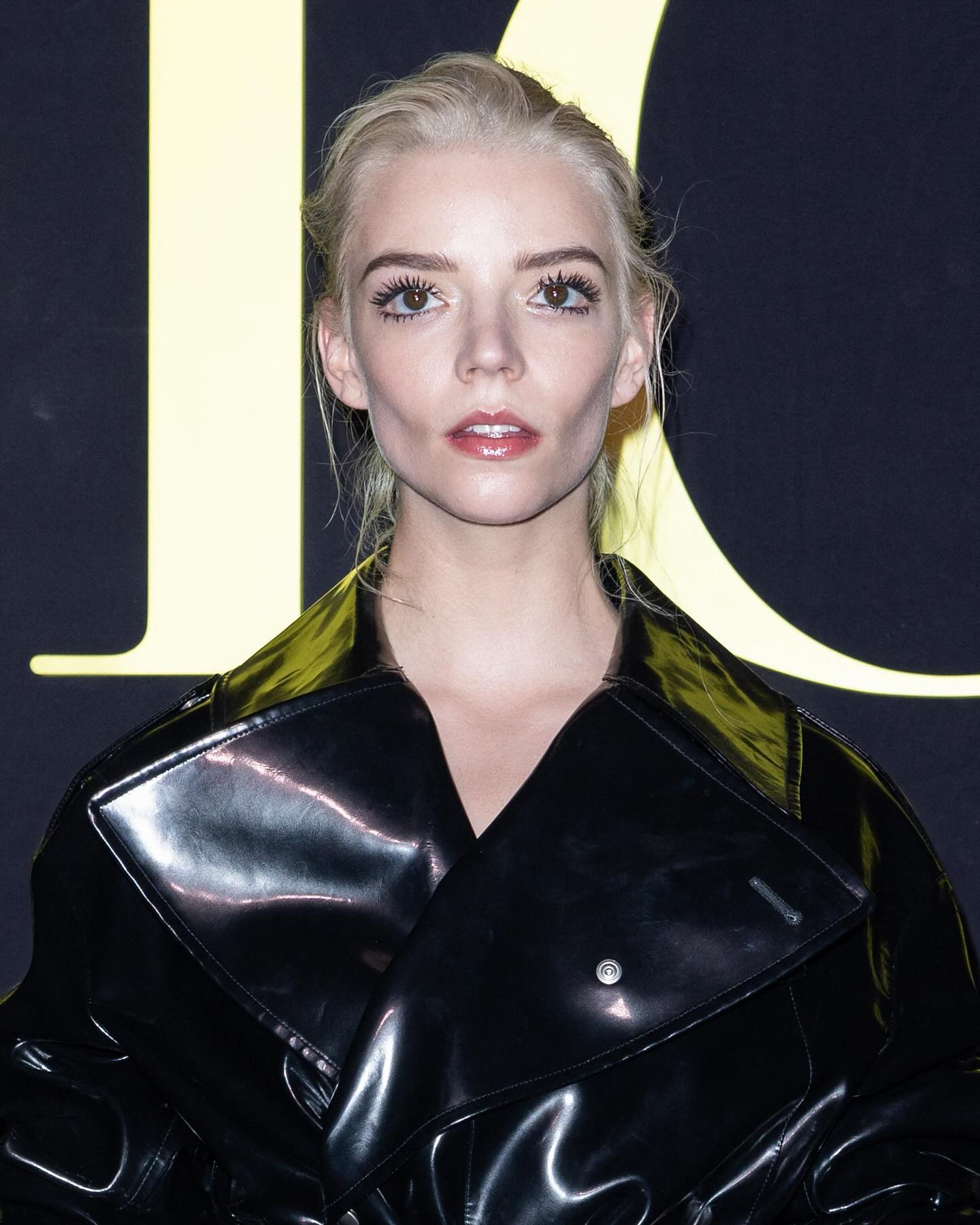 A blonde woman with a black leather jacket and yellow hair. - Anya Taylor-Joy