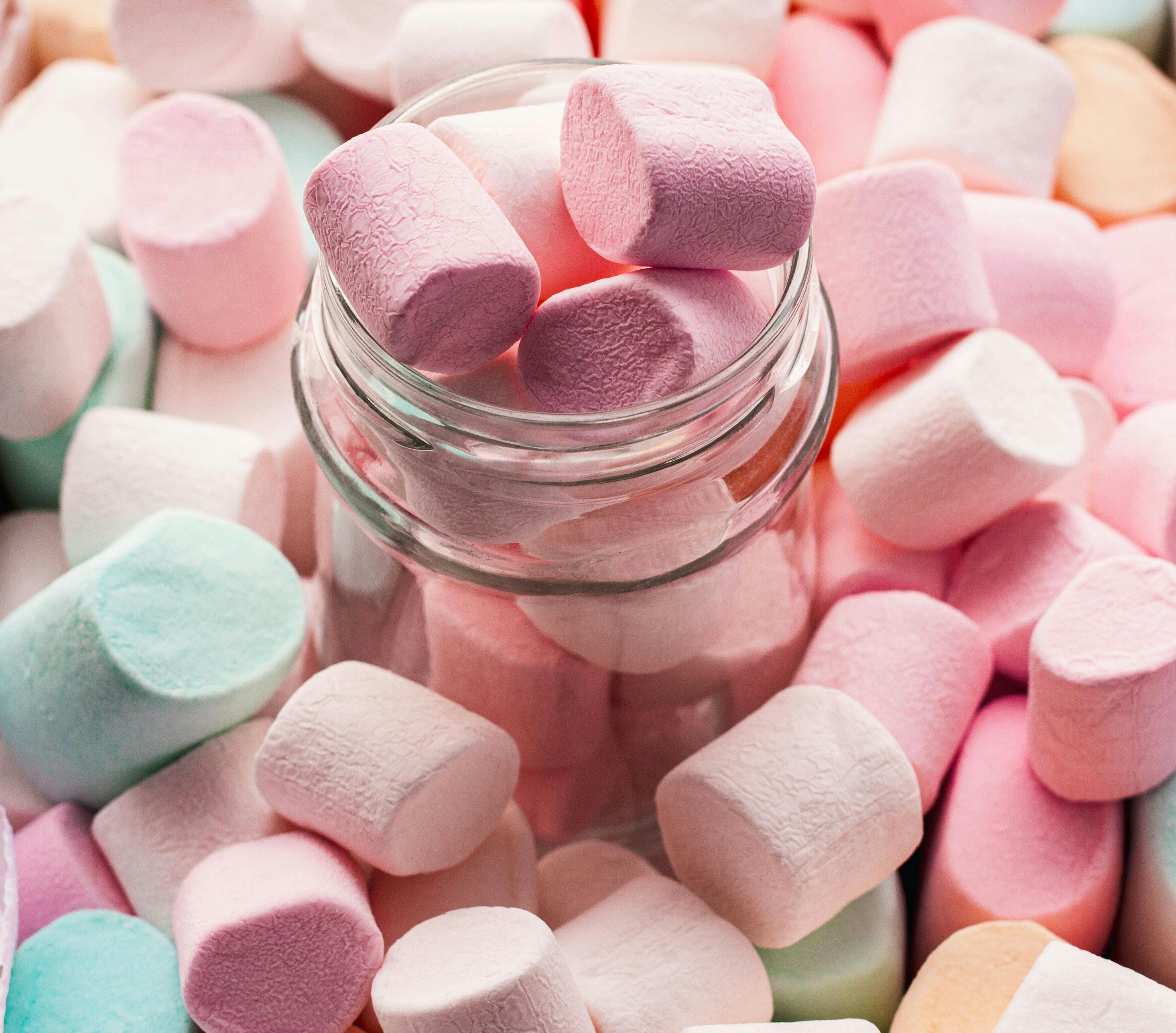 A jar of marshmallows in a variety of colors. - Marshmallows