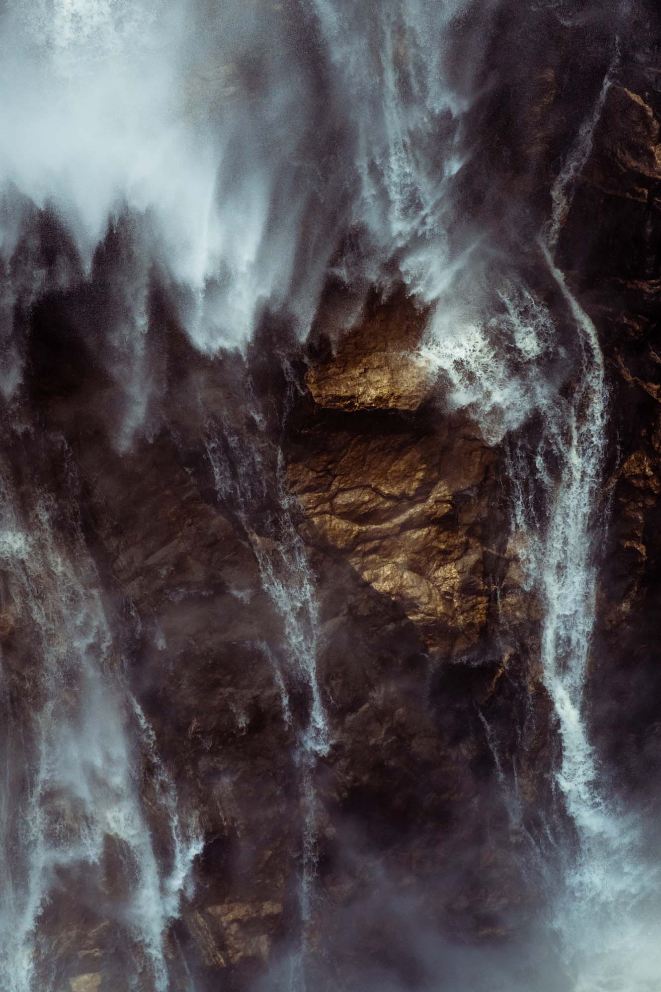 A waterfall crashes into a rock face. - Waterfall