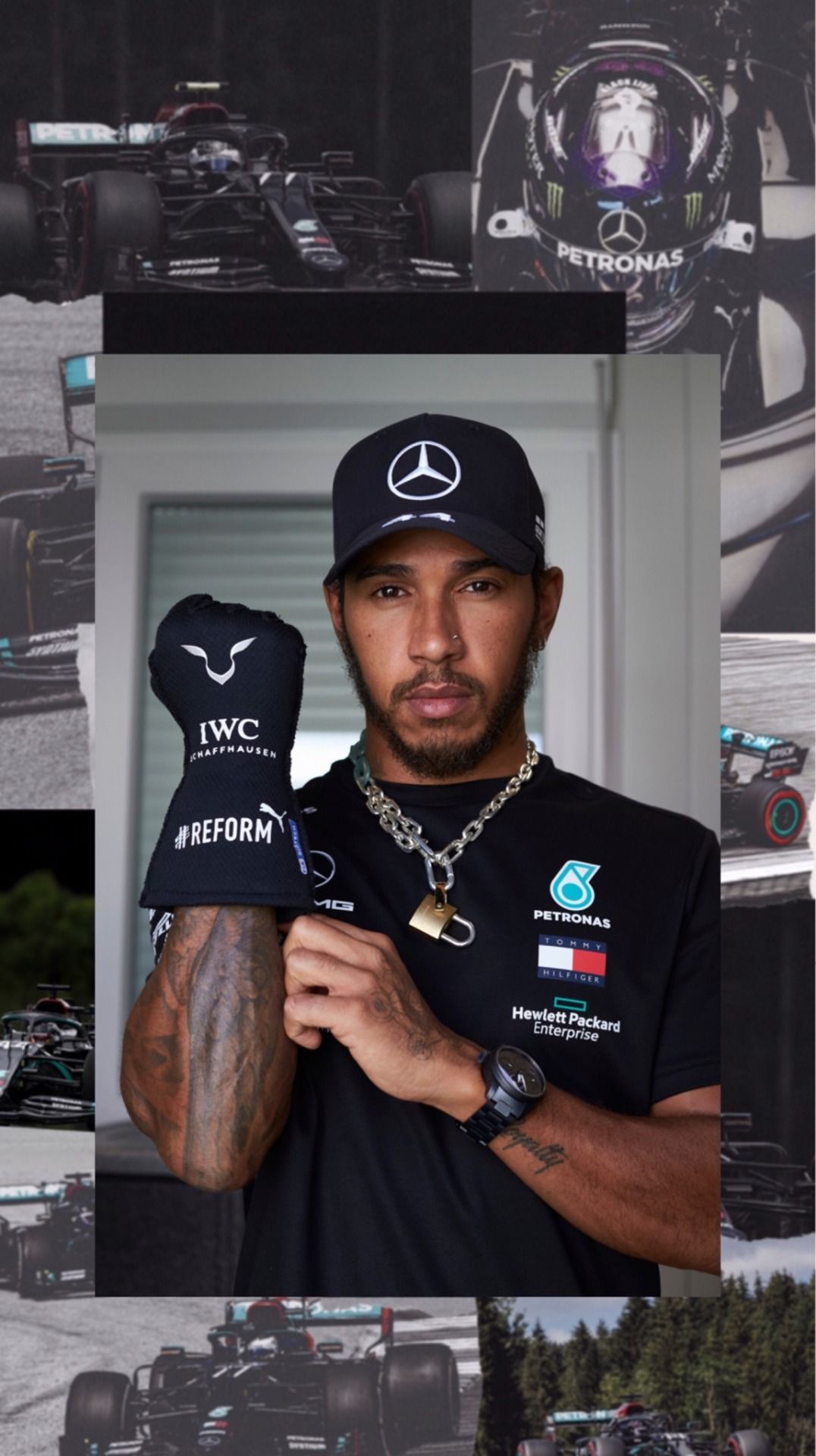 Lewis Hamilton wearing a black Mercedes cap and holding a black cap with the words 
