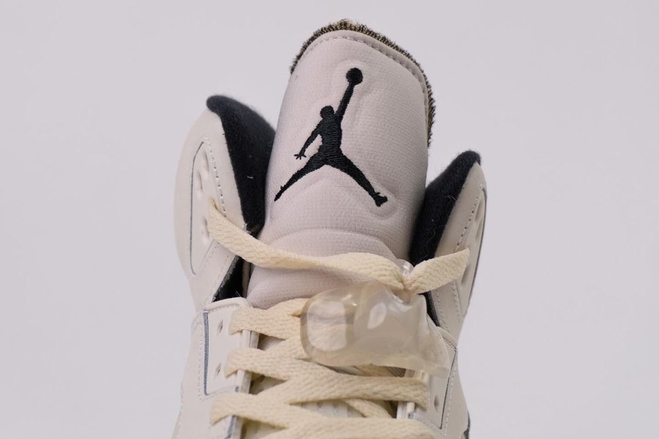 A pair of Jordan 5 shoes in white and black color scheme are shown on a white background. - Air Jordan 5