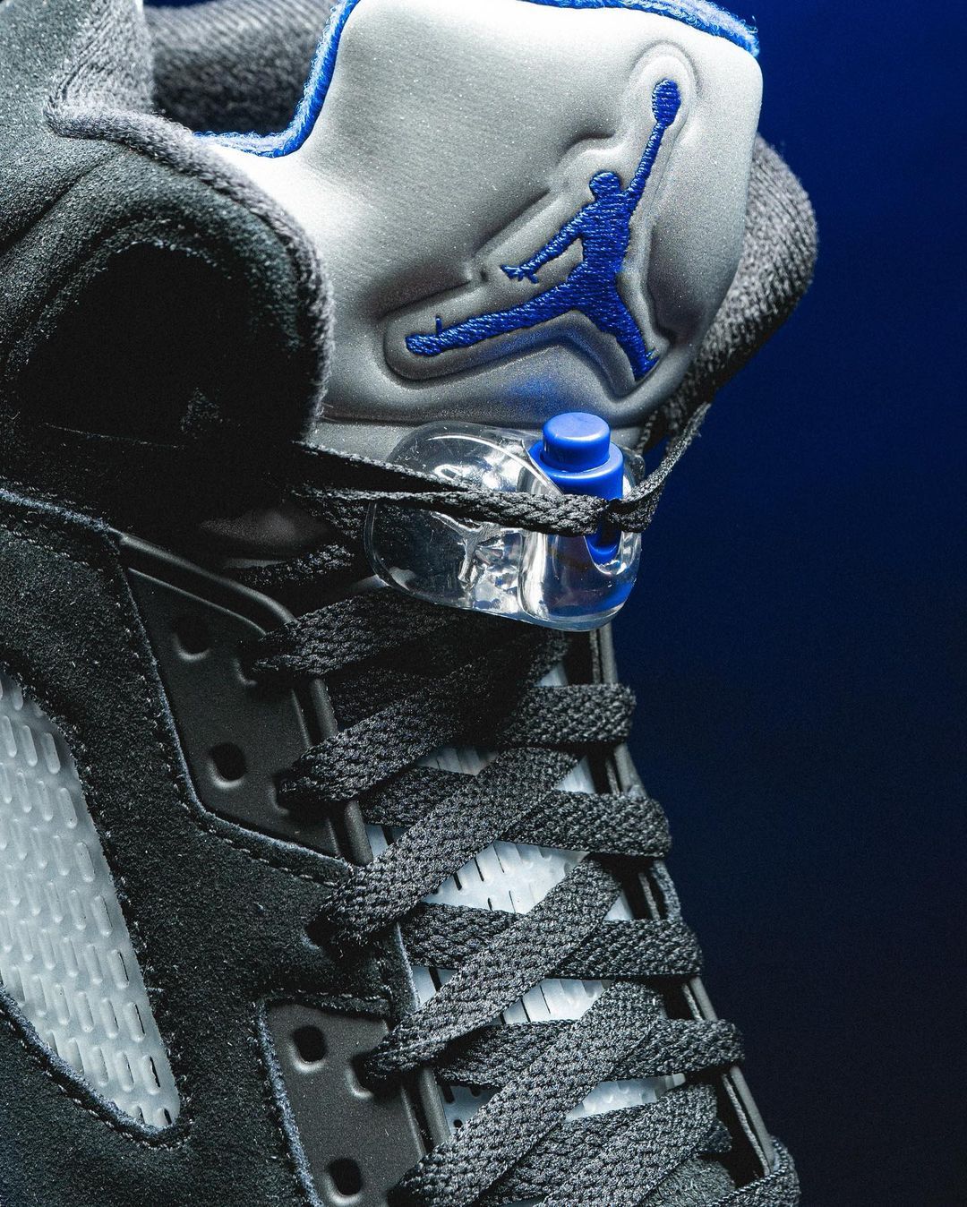 A pair of black and blue sneakers with a blue Jumpman logo - Air Jordan 5