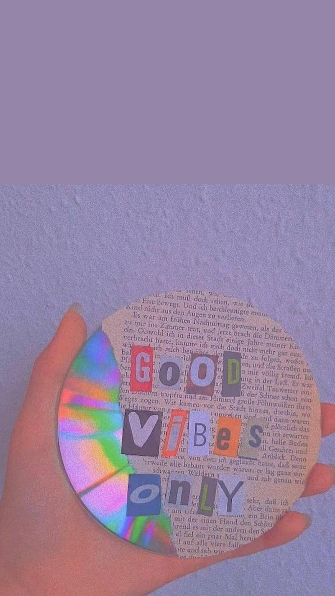 A person holding up an object with the word good vibes only on it - Indie