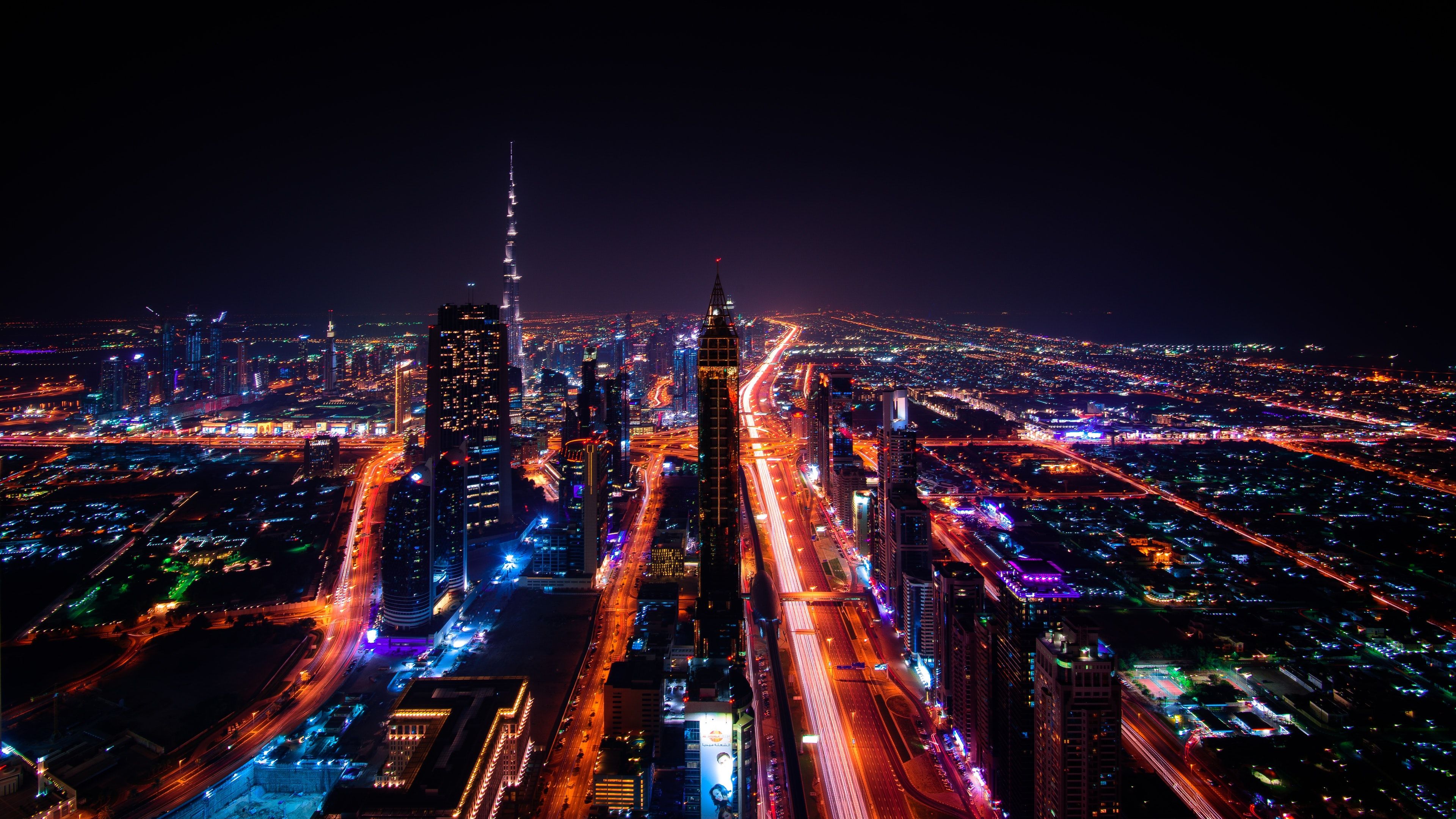 A night time cityscape of Dubai with a mix of street and tower lights. - Dubai