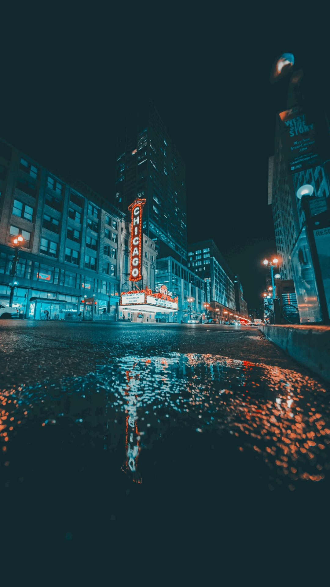 IPhone wallpaper of a city street at night with a puddle in the foreground. - City, night