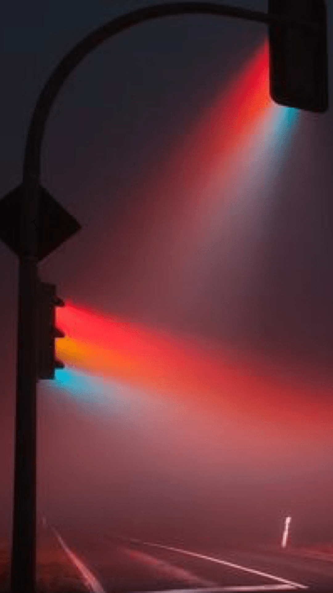 A traffic light is lit up with a rainbow of colors. - IPhone red