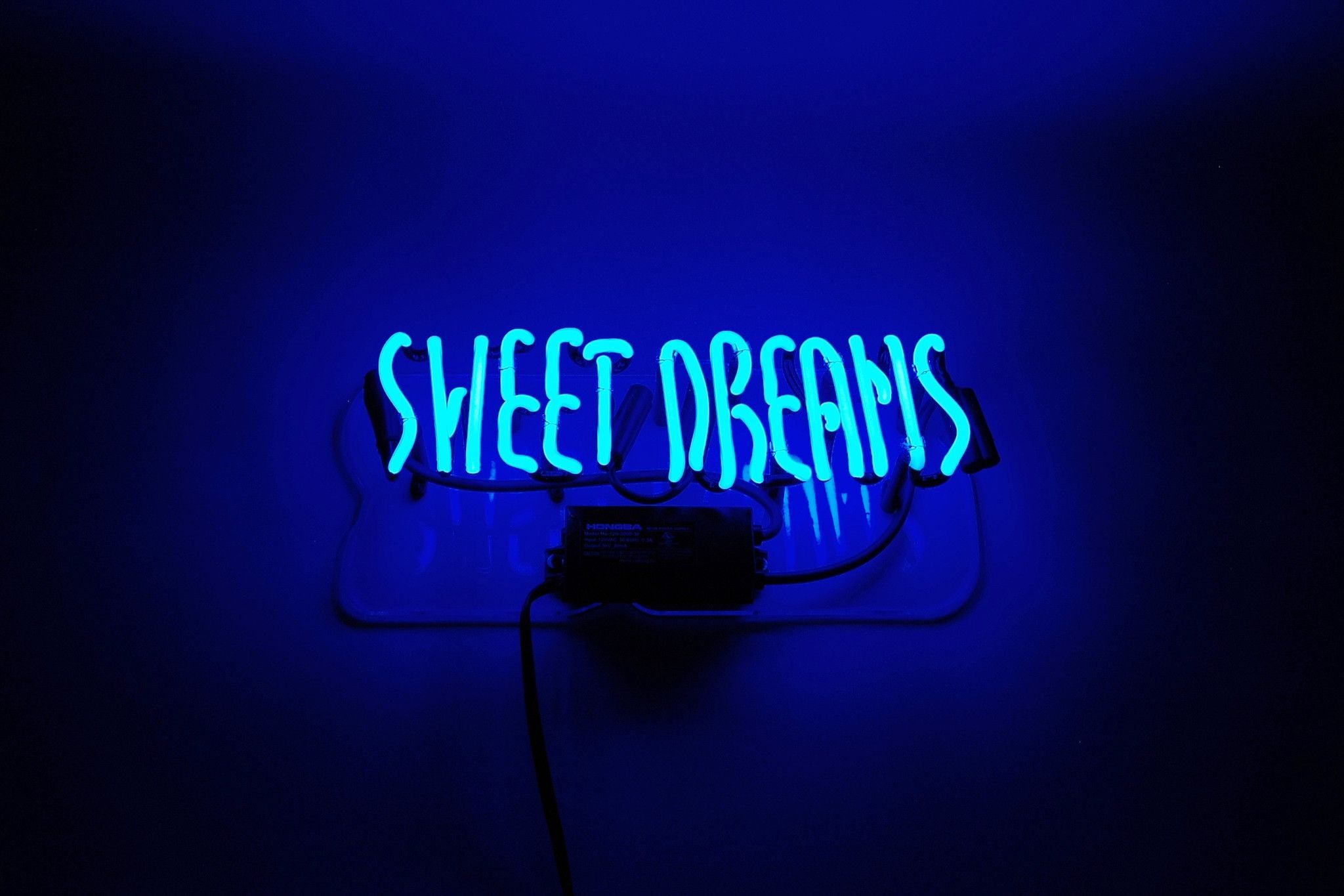 A blue neon sign that says sweet dreams - Neon blue