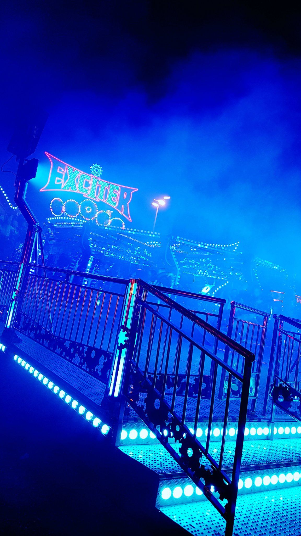 A blue neon lit roller coaster at night. - Neon blue