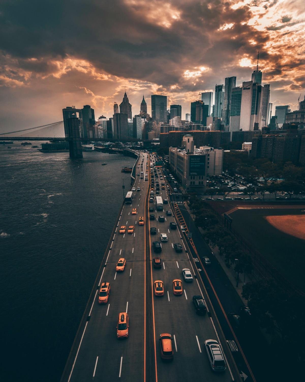 A busy highway with cars and taxis leading into a city. - City, road, New York