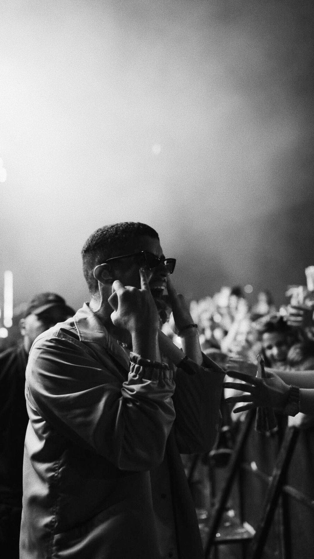 A man talking on his cell phone at an event - Bad Bunny