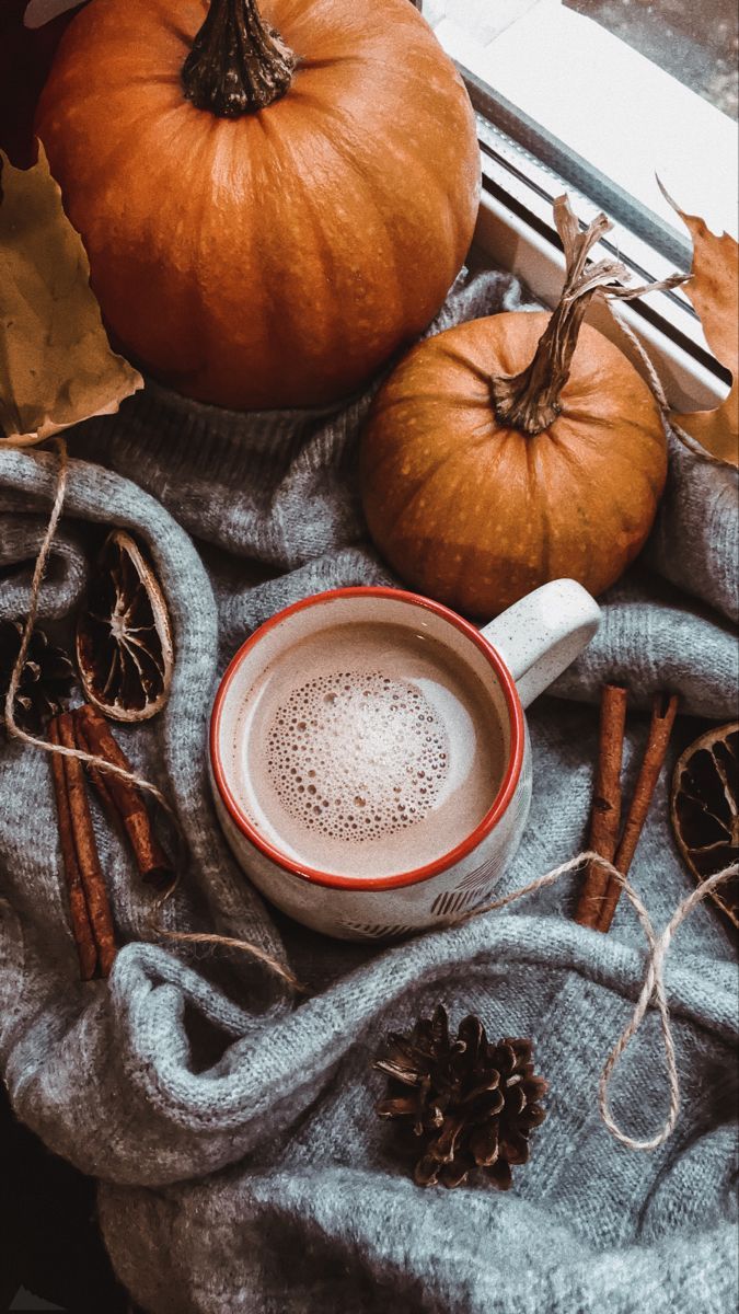 A cup of coffee with cinnamon sticks and pumpkins on a table - Vintage fall