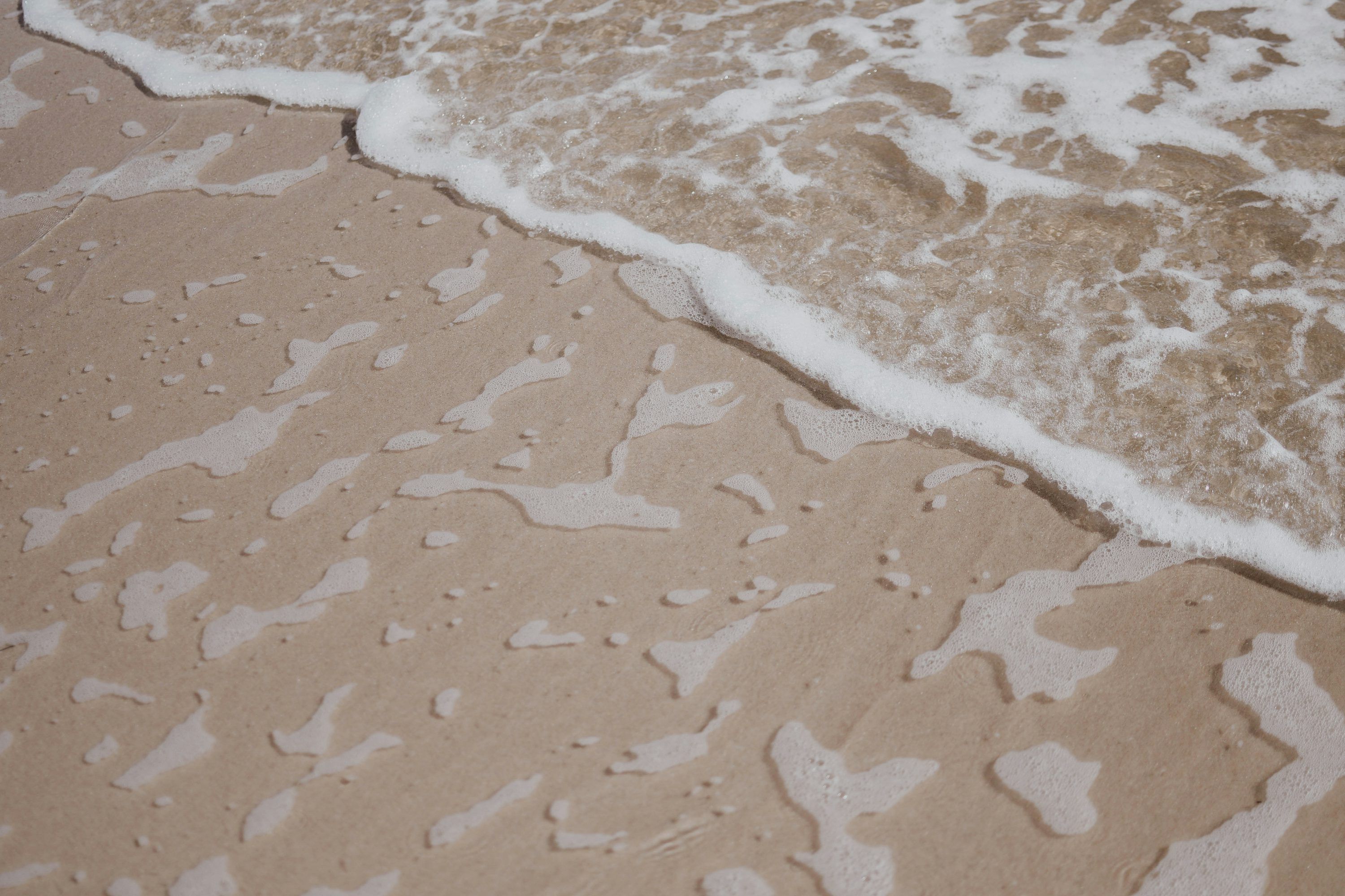 A close up of water and sand on a beach