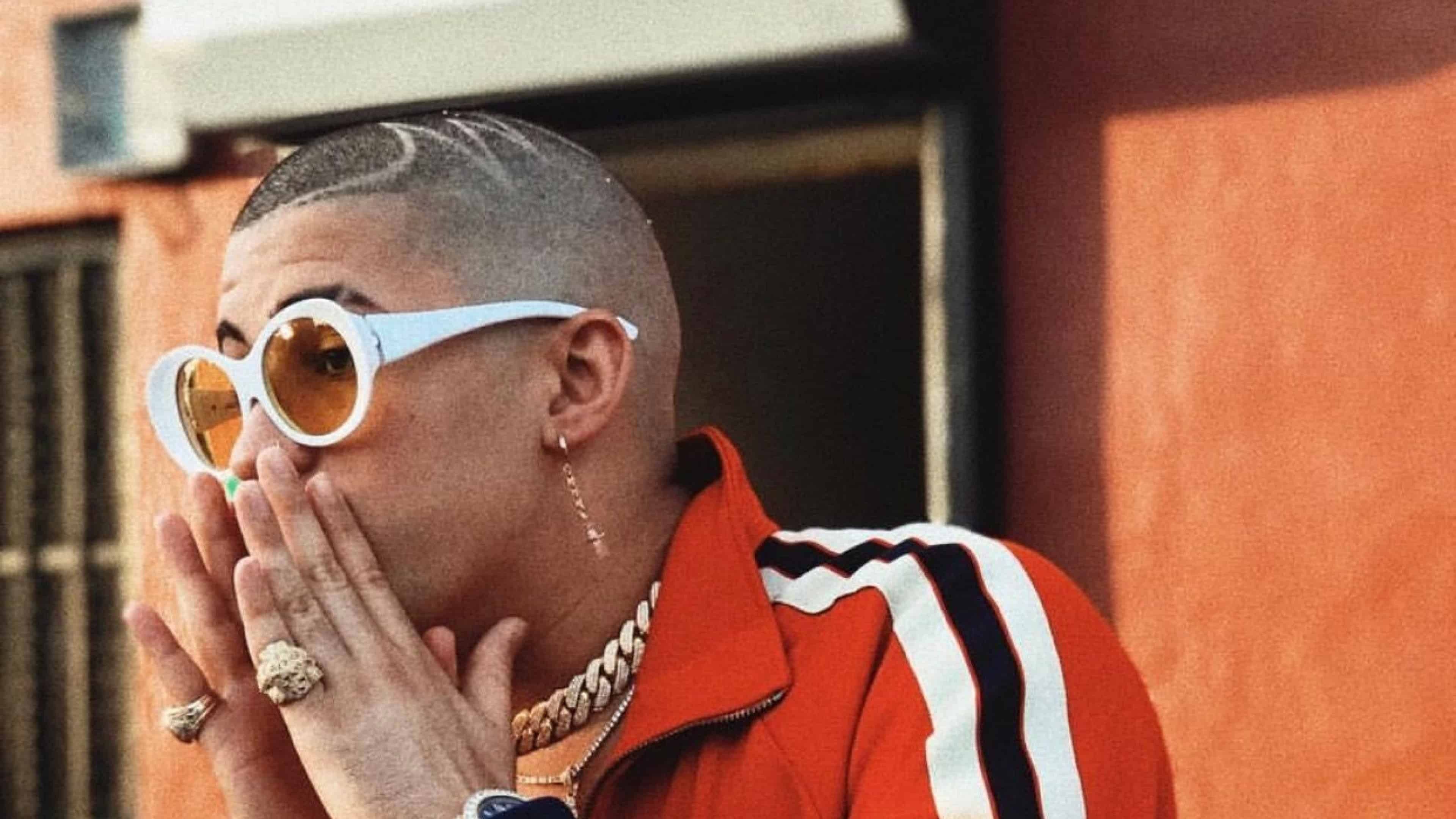 Cool Bad Bunny Aesthetic Is Having Hands On Mouth Wearing Orange Shirt And White Sunglasses 4K HD Music Wallpaper