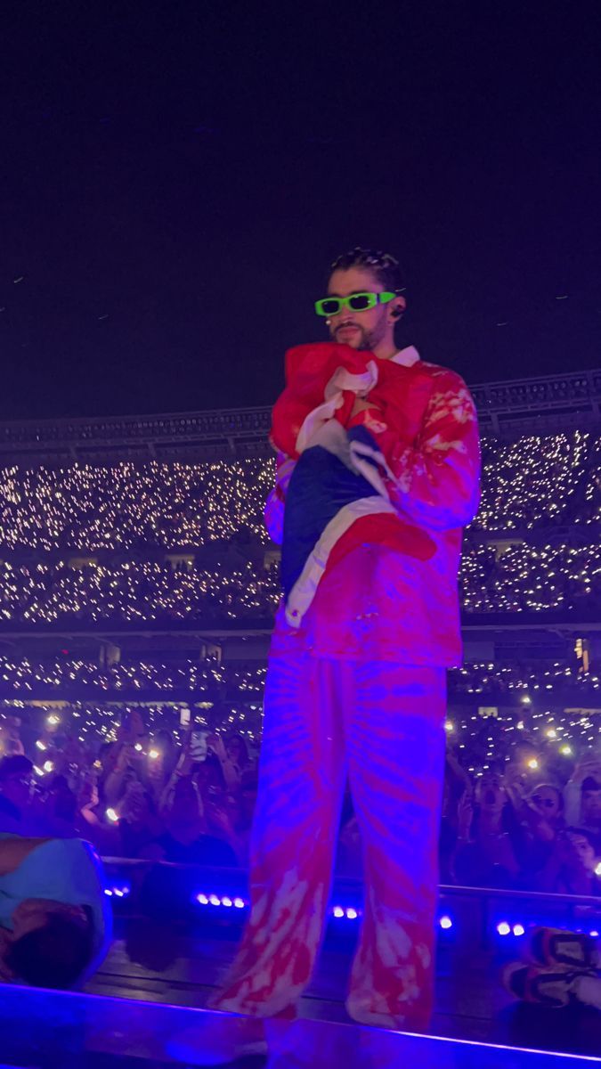 A man in pink and red holding up an object - Bad Bunny