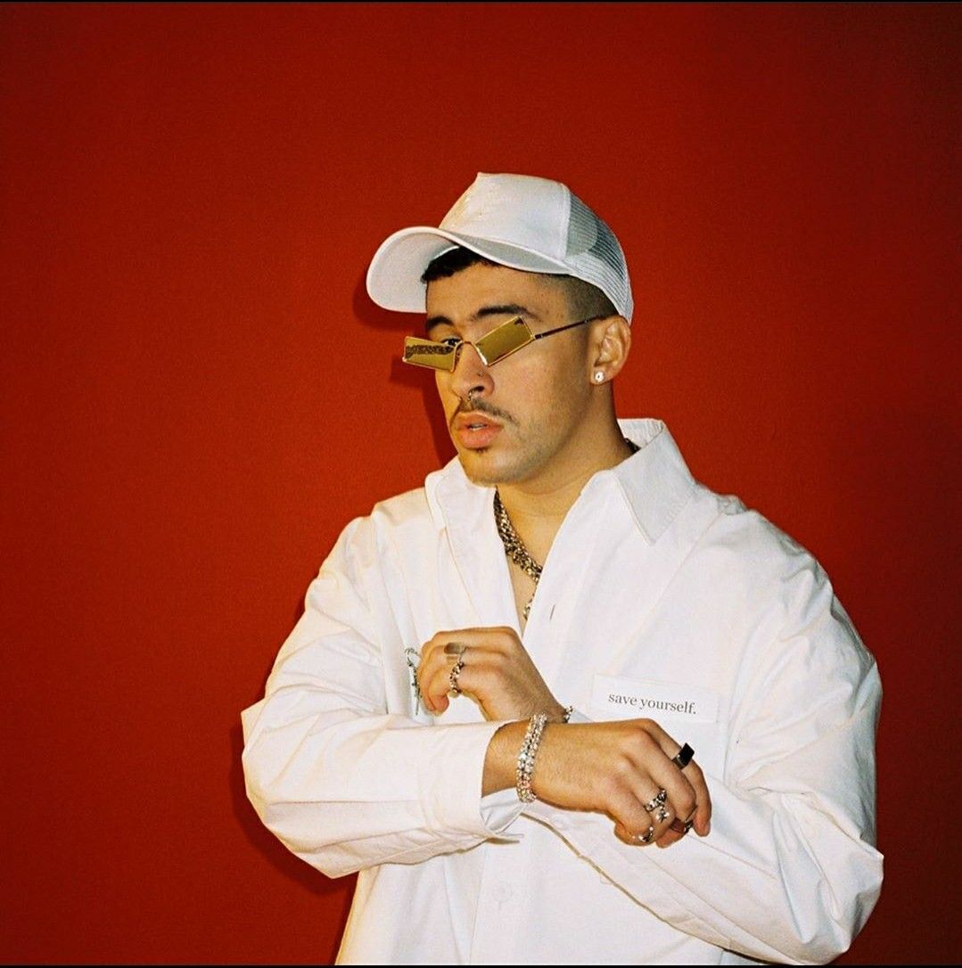 A man in white clothes with sunglasses on - Bad Bunny