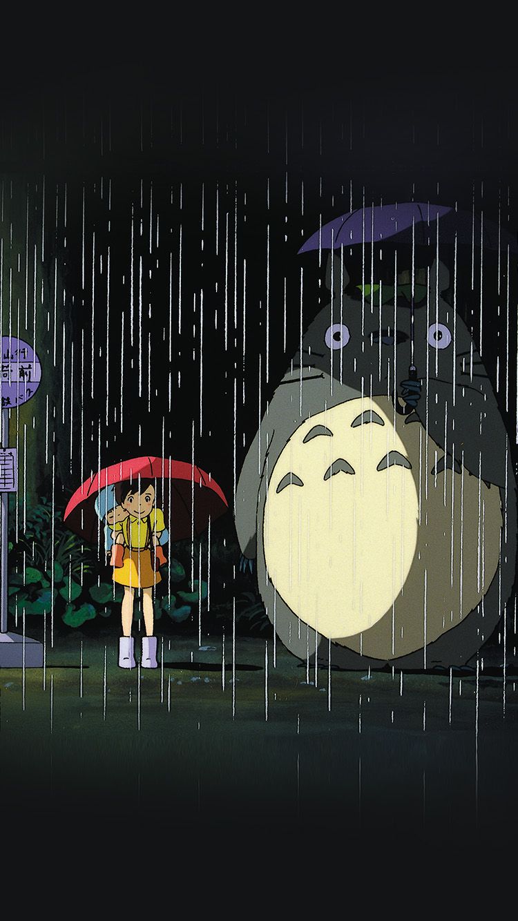 A still from My Neighbor Totoro, featuring a young girl and a giant cat-like creature standing in the rain under umbrellas. - Rain