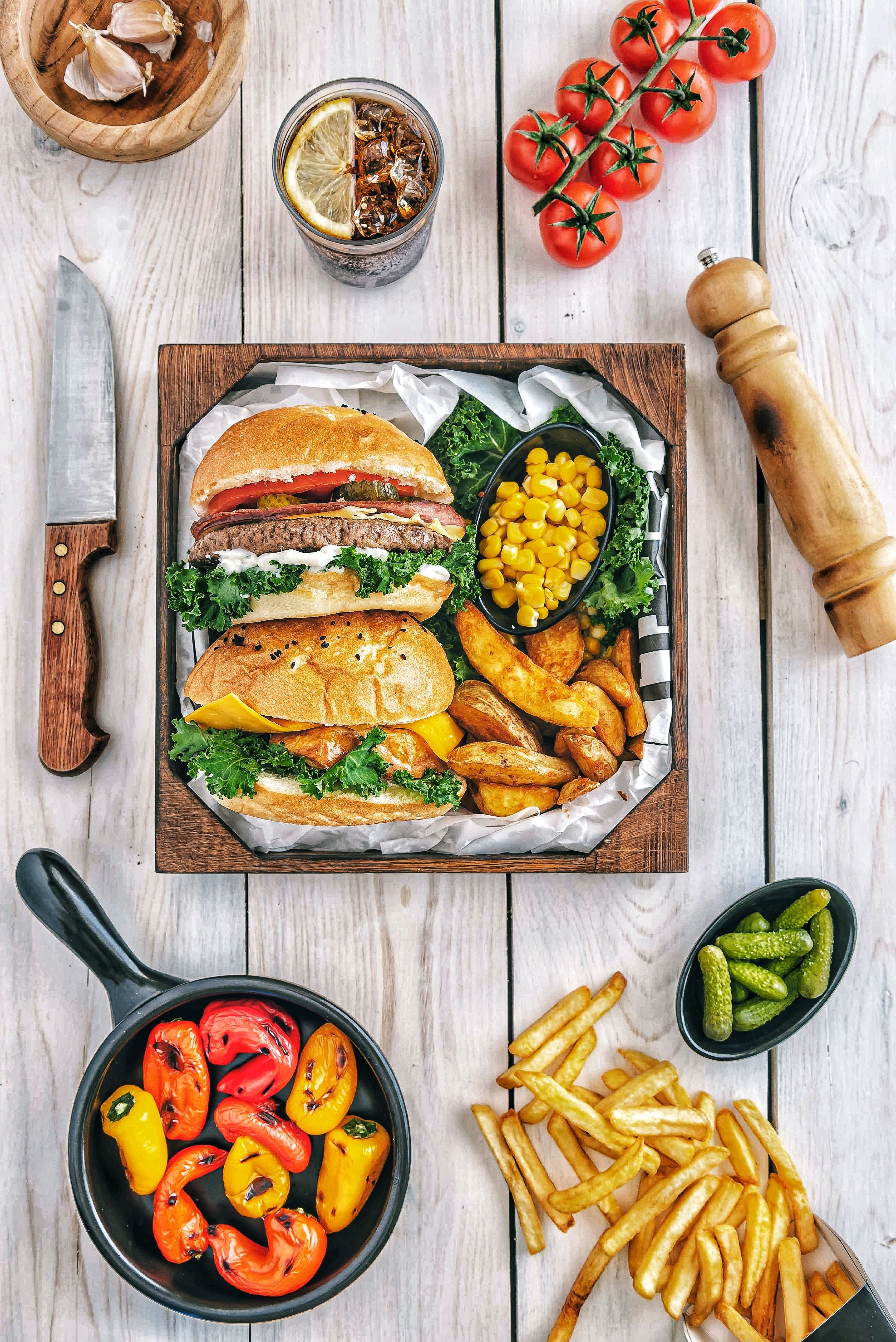 A table with two sandwiches, fries, and vegetables. - Foodie