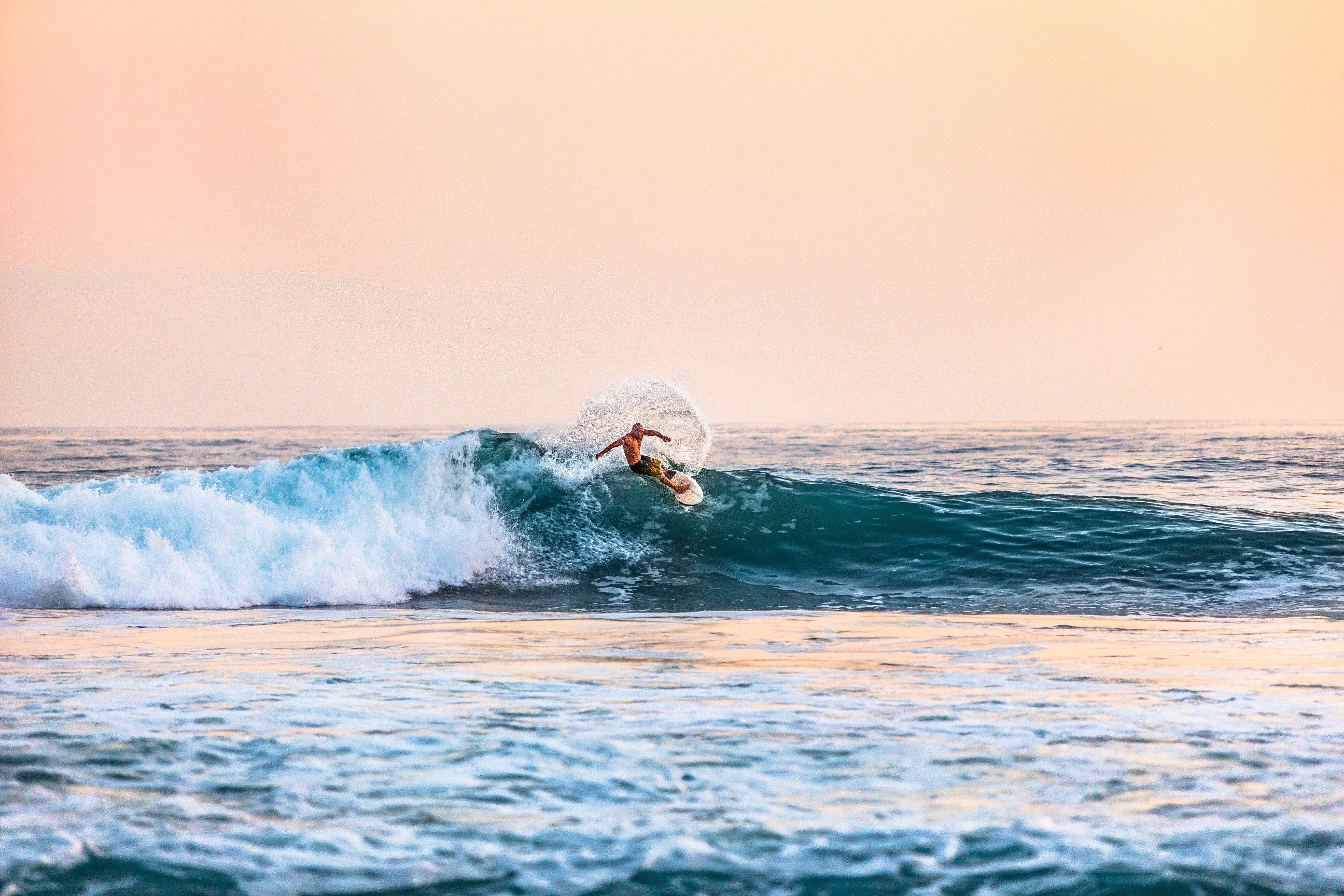 A surfer riding on top of an ocean wave - Surf