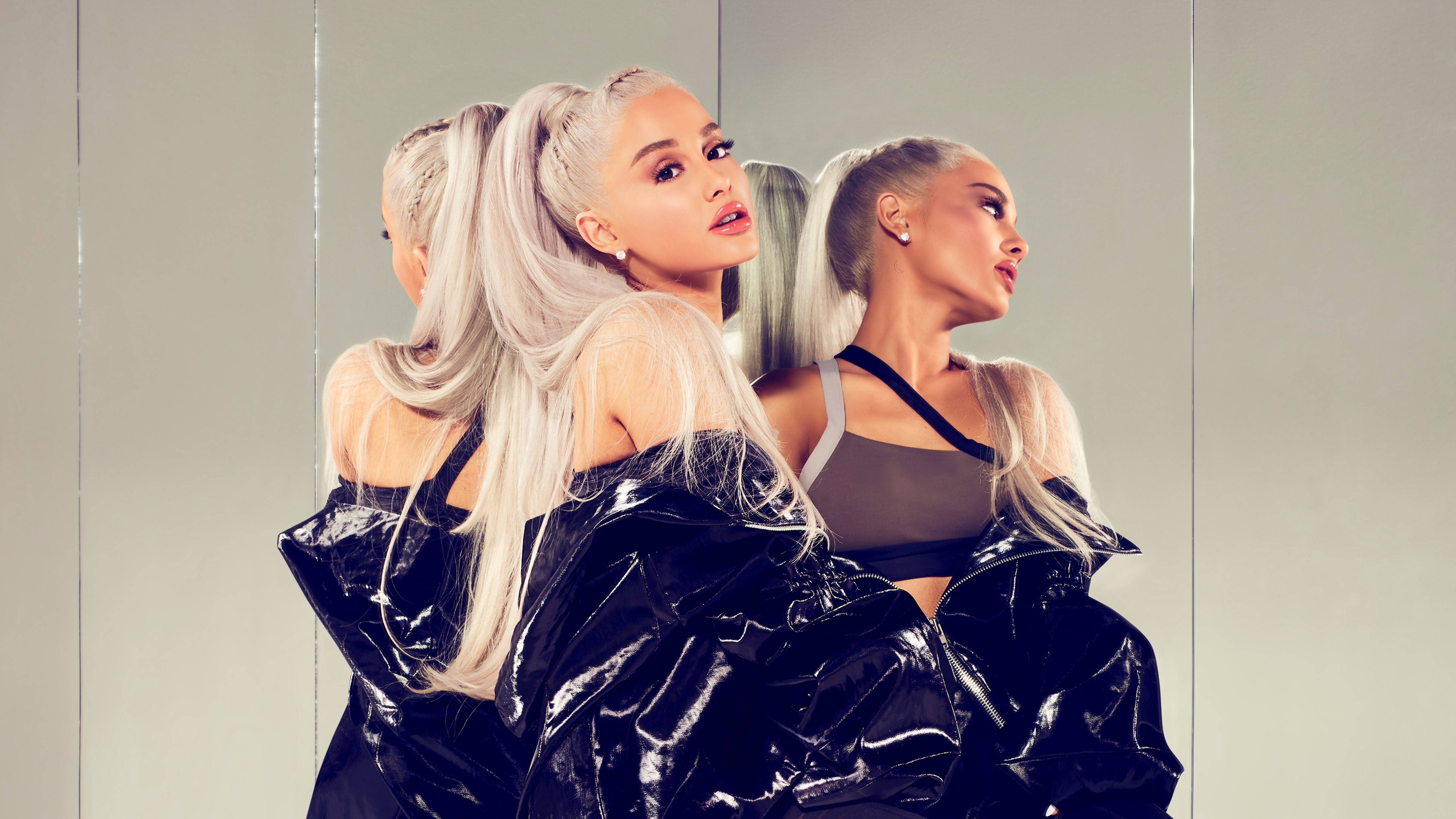 Ariana Grande with blonde hair and a black jacket in front of a mirror - Ariana Grande