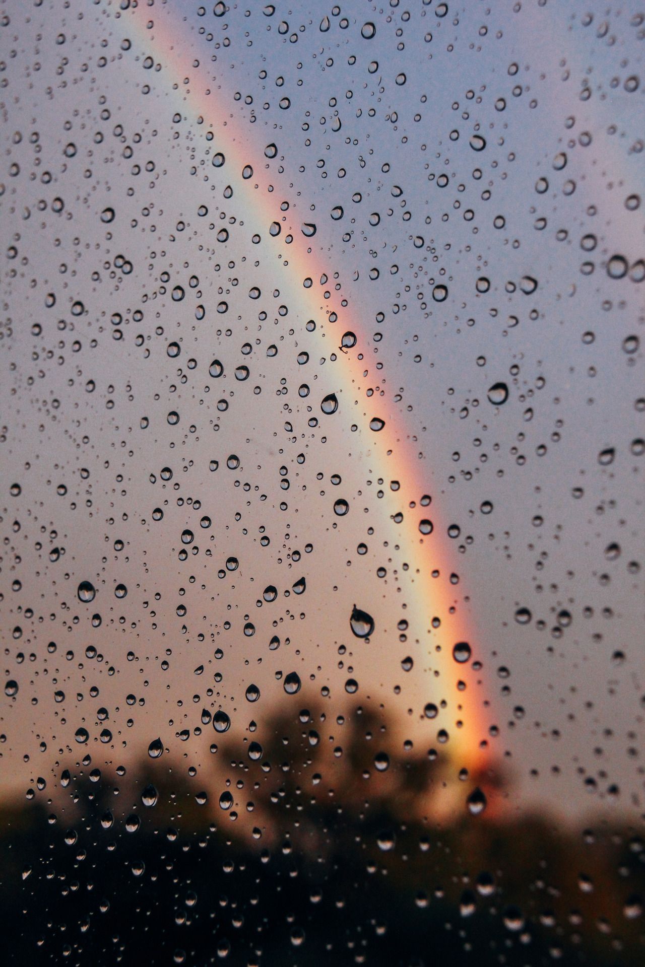 A rainbow through a window with raindrops on it - Rain