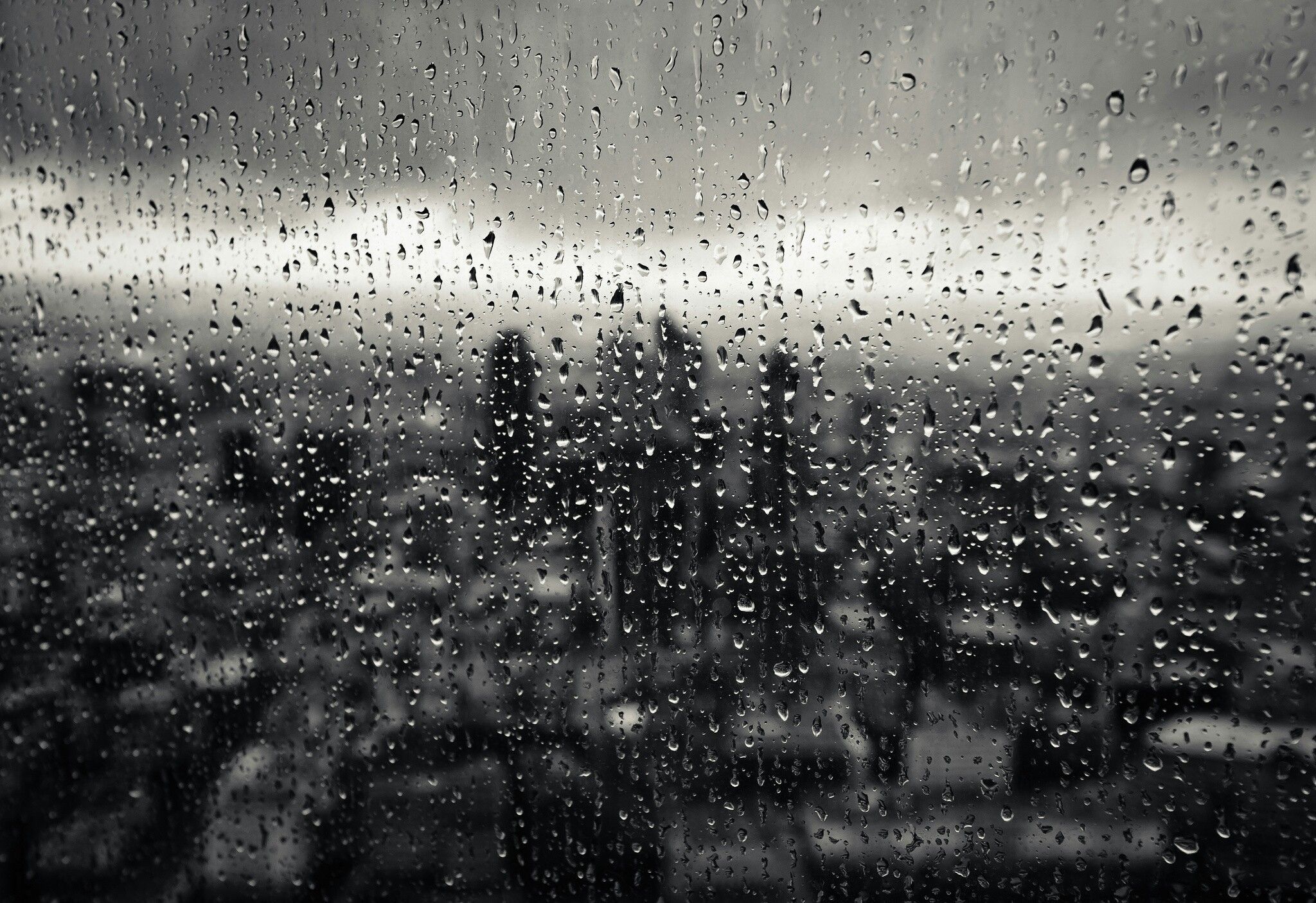 A black and white photo of rain on the window - Rain