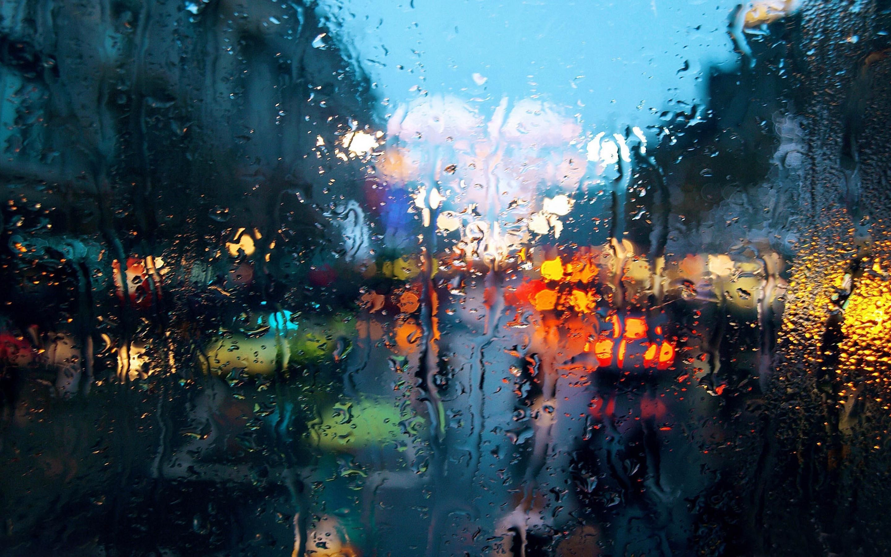 A view of a city street through a rain-streaked window. - Rain