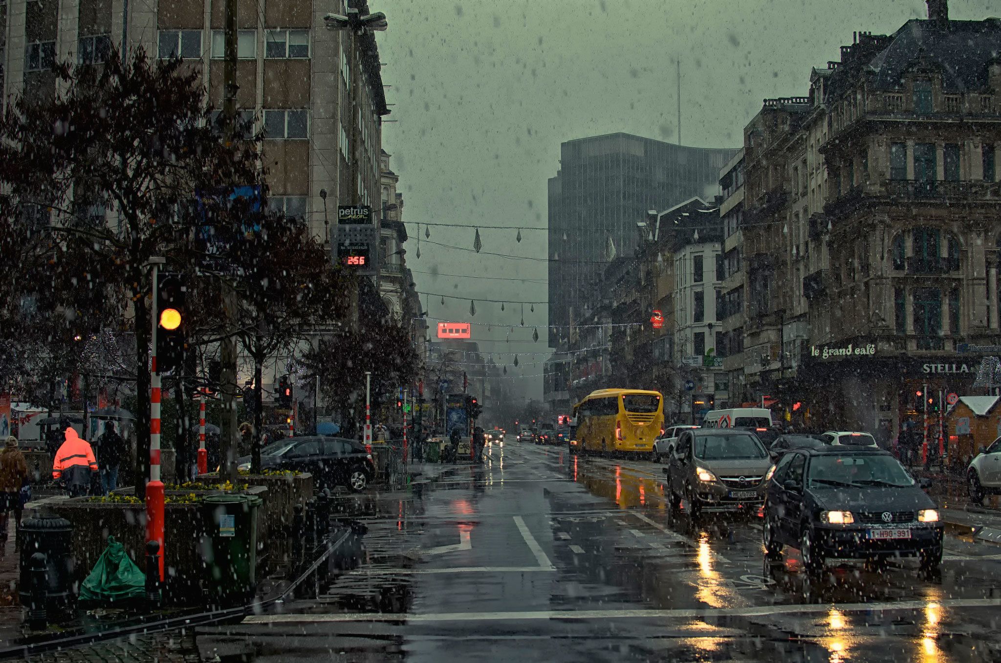 A city street with cars and buildings - Rain