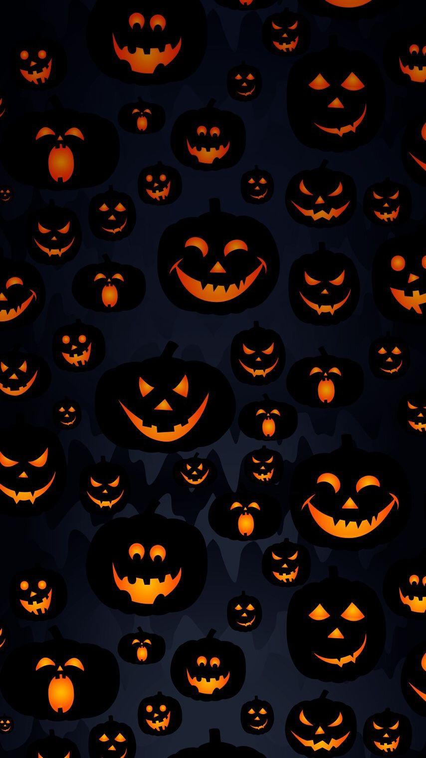 Scary Halloween pumpkins on a dark background. - Halloween